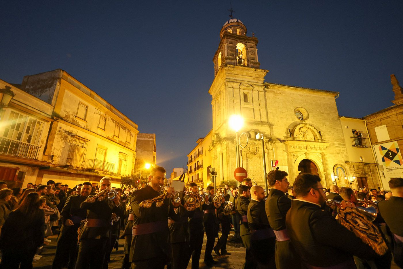 La Banda de Cornetas y Tambores Nuestra Señora de la Victoria, Las Cigarreras, revirando por la iglesia de la Victoria.