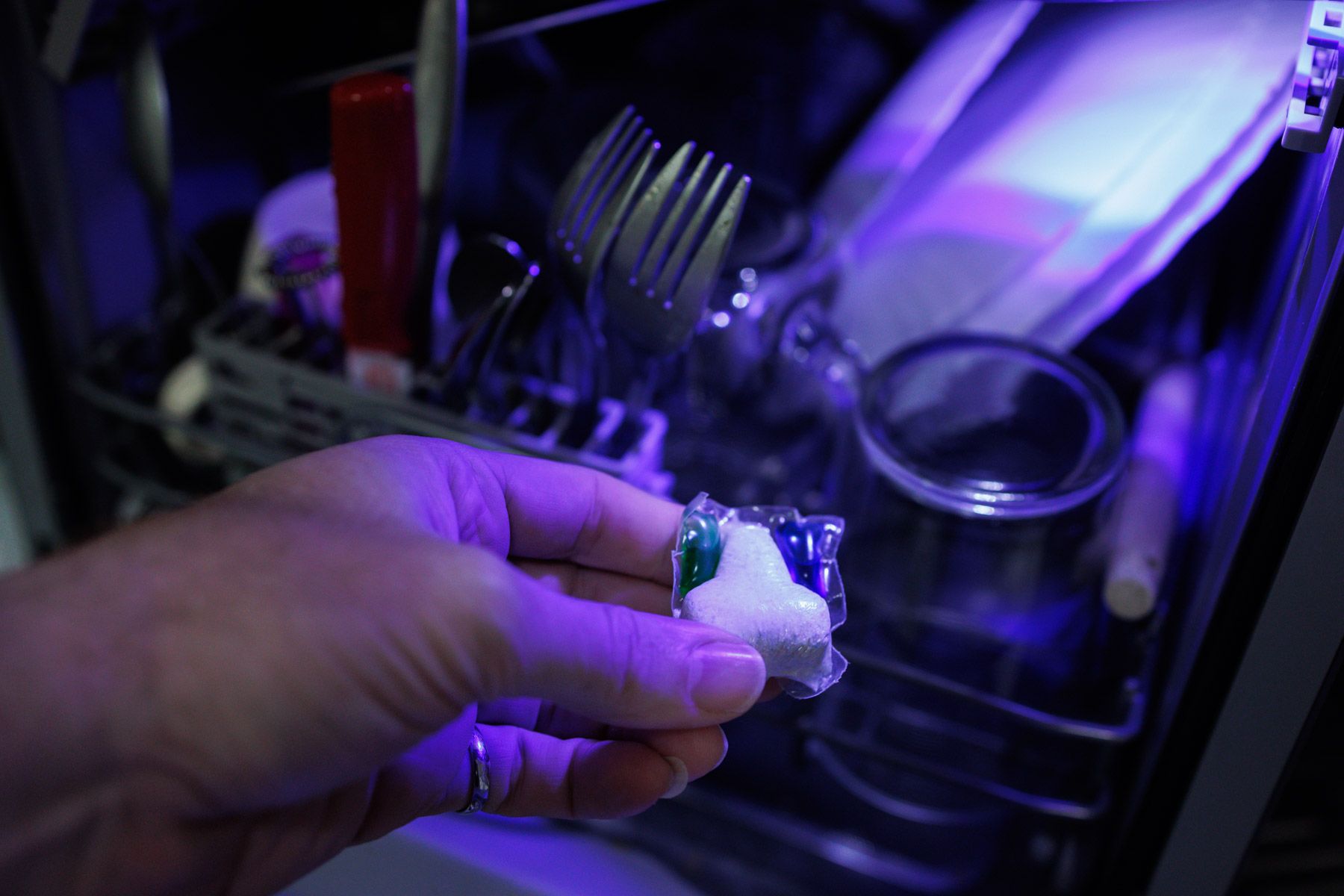 Una persona poniendo el lavavajillas.