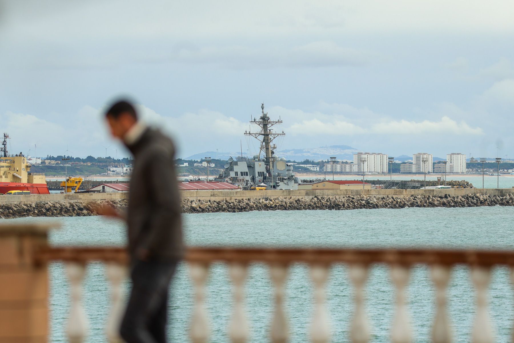 Vecinos se acercan a ver la Base Naval de Rota desde la playa del Chorrillo.