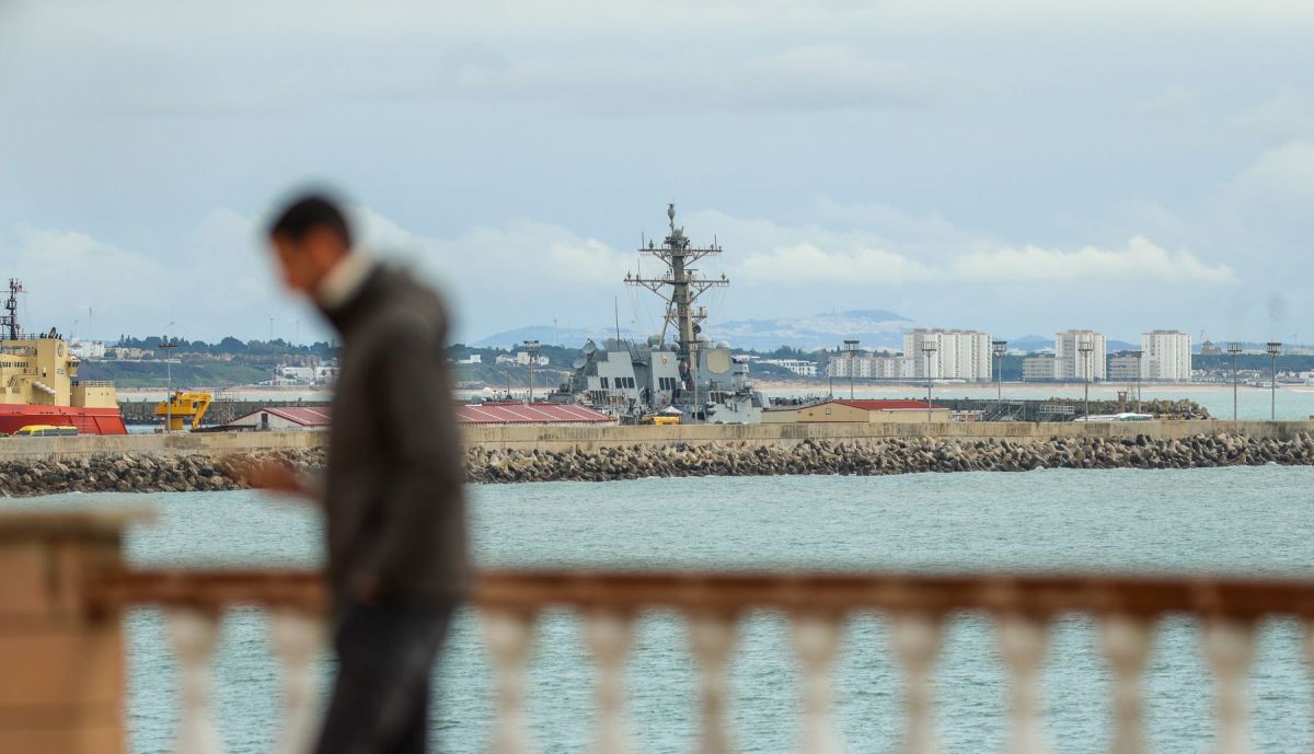 Vecinos se acercan a ver la Base Naval de Rota desde la playa del Chorrillo.