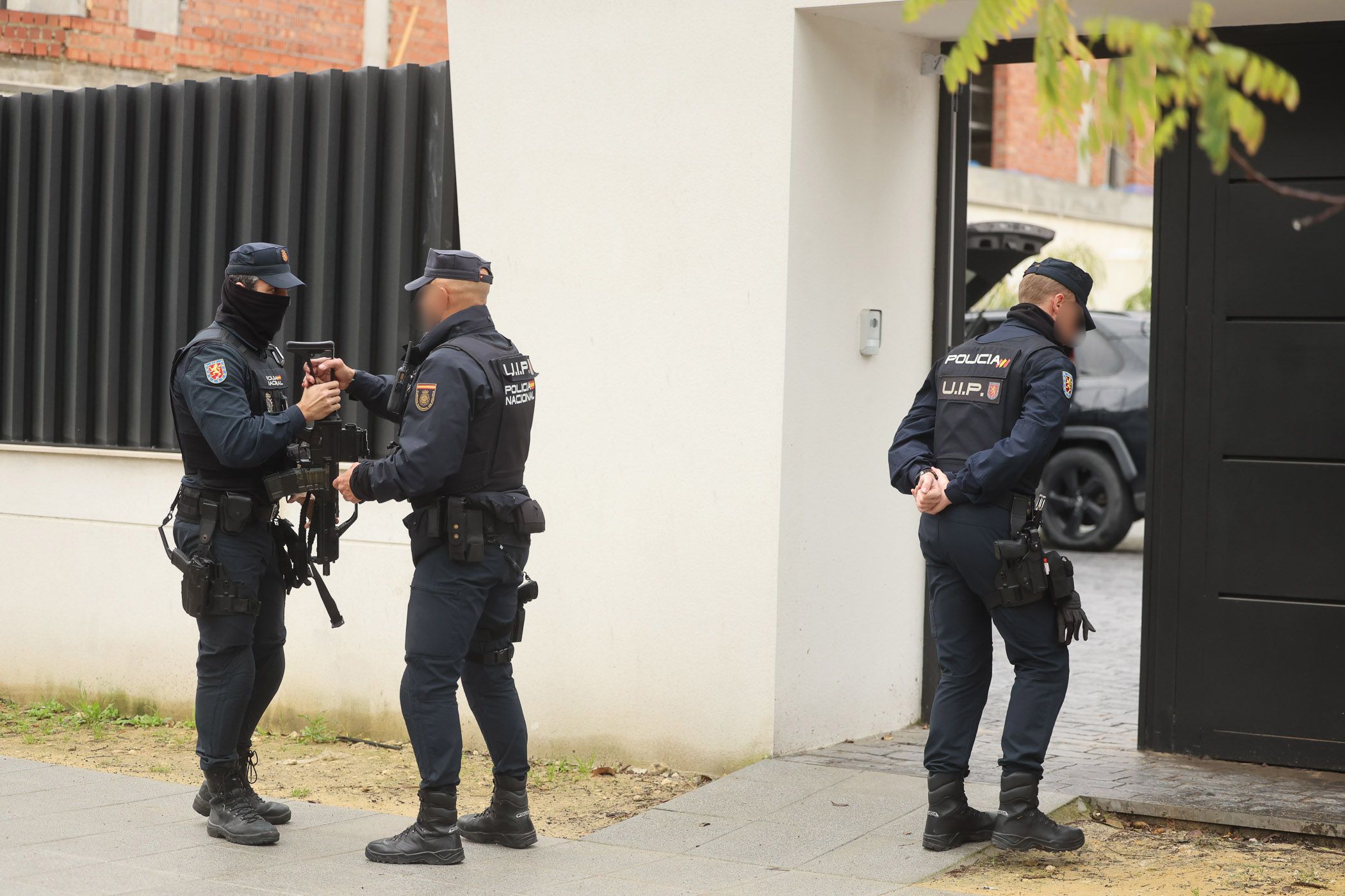 Agentes custodiando la vivienda donde se realiza el registro.
