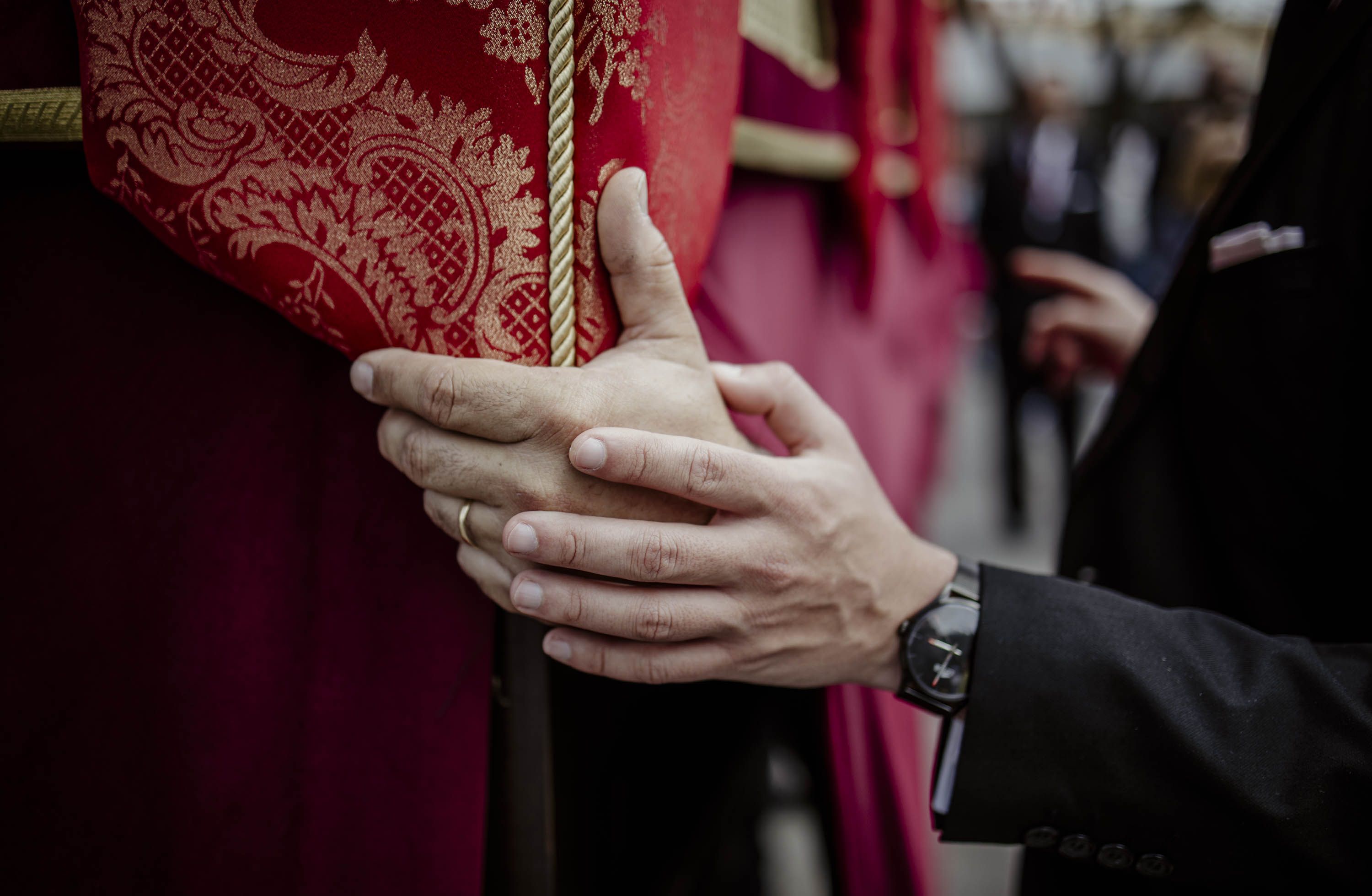 La mano del capataz sobre la de un costalero.