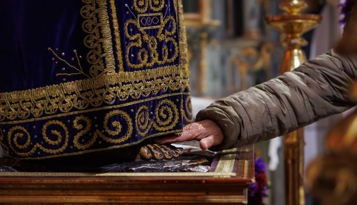 Una devota tocando el pie del Cautivo. 
