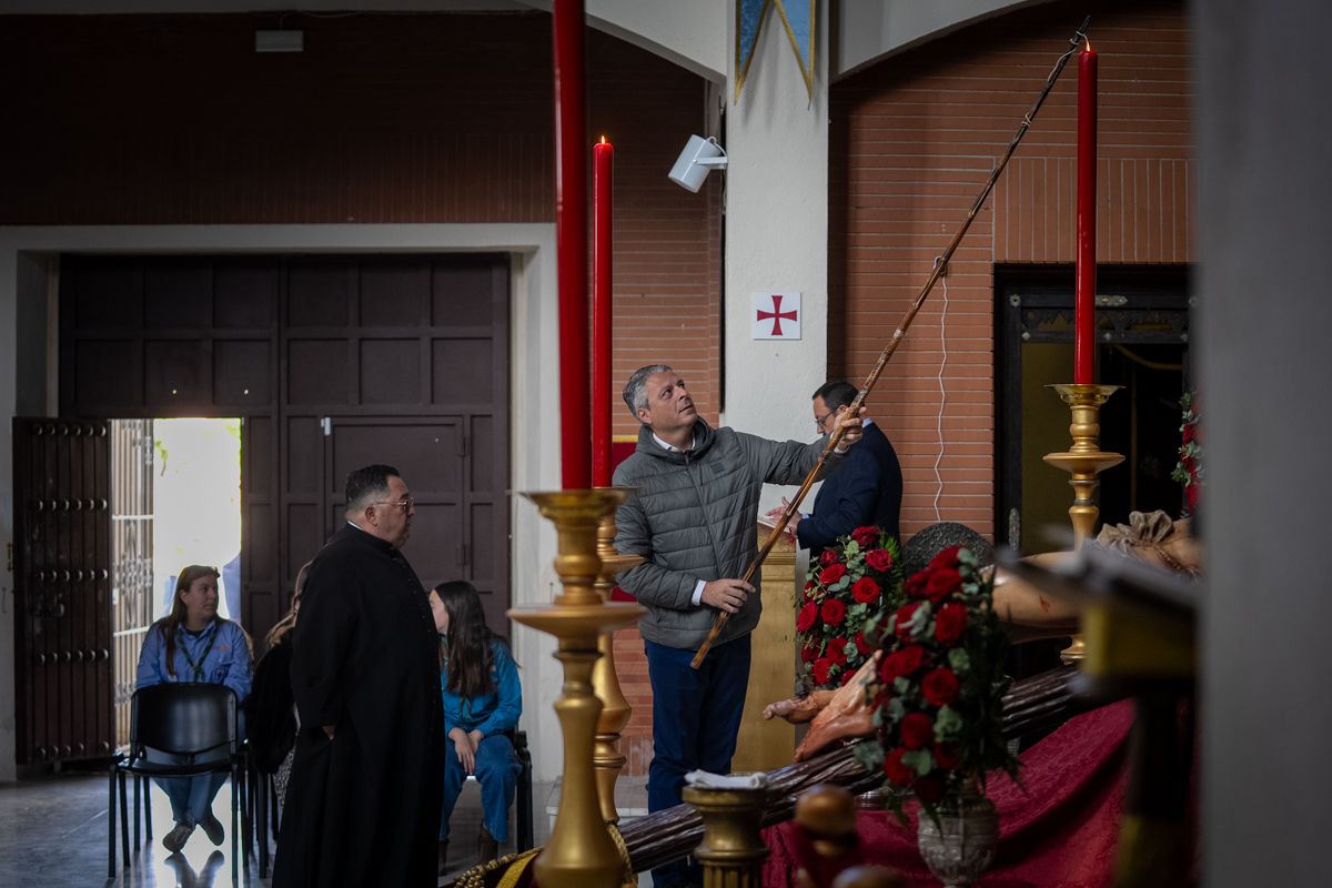 Un hermano encendiendo la cera del altar en las Viñas. 