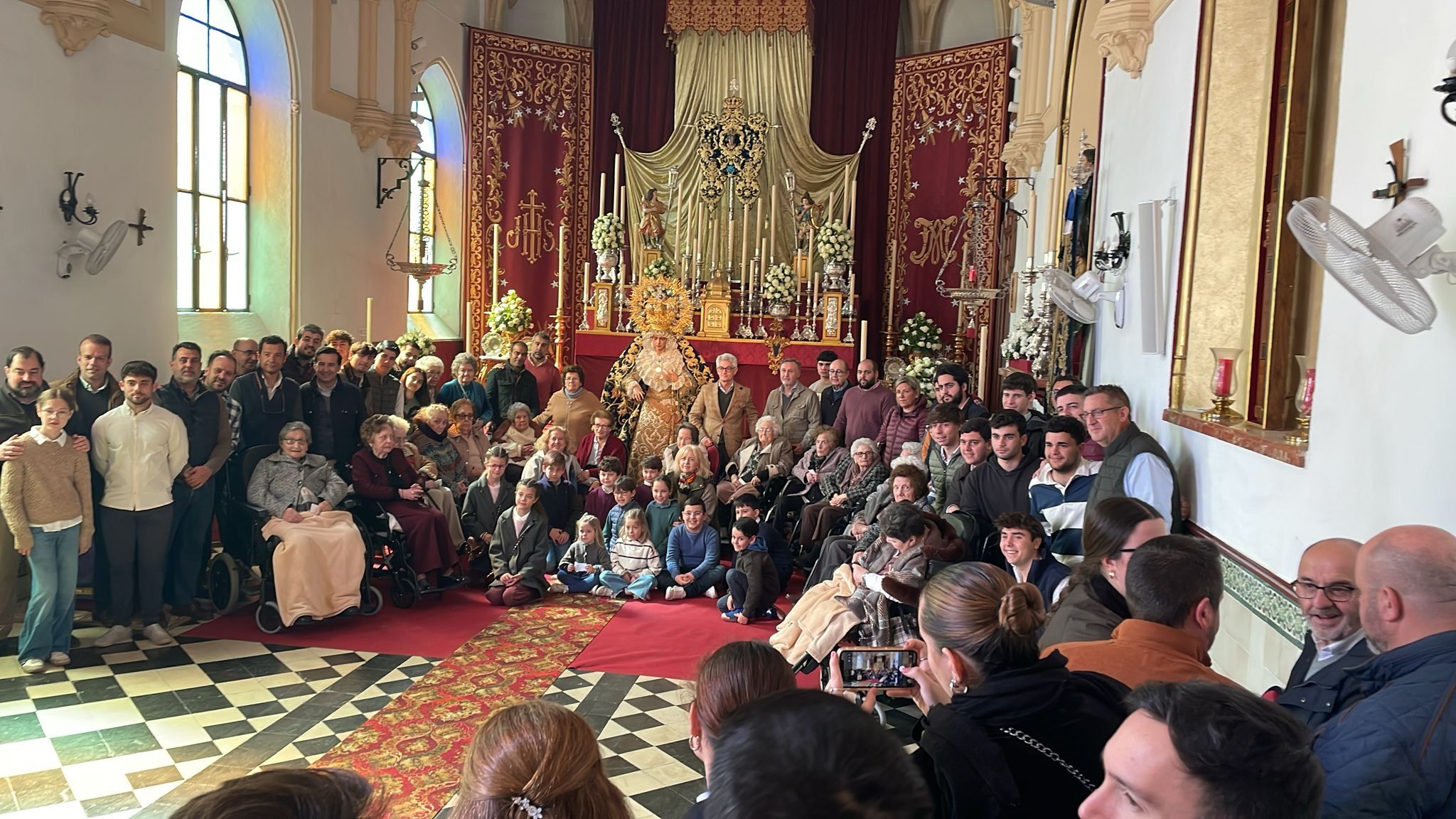 La Virgen de la Estrella rodeada de mayores y jóvenes de la hermandad.  