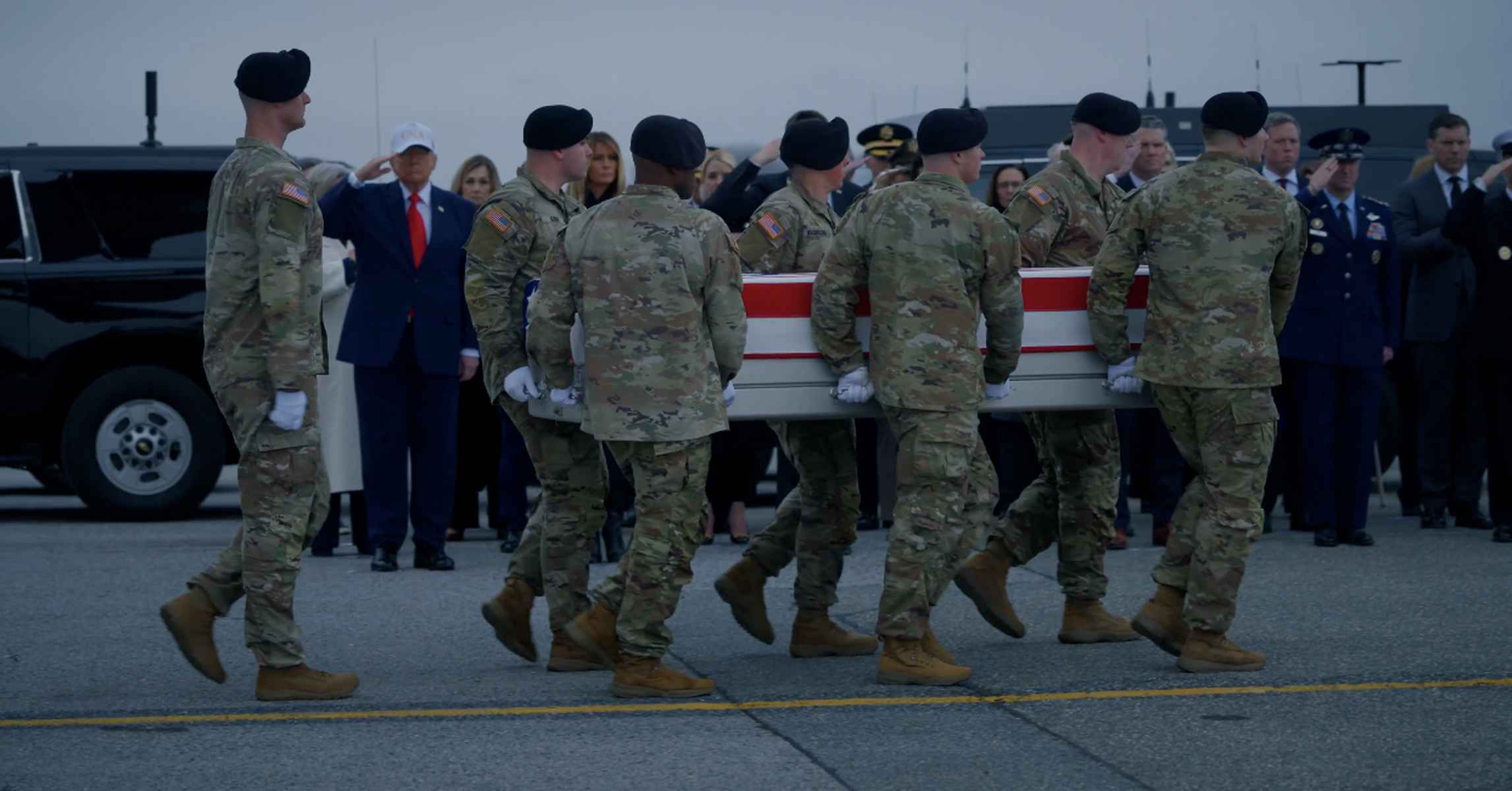 Donald Trump, al fondo con gorra blanca, recibiendo el féretro de uno de los soldados muertos en la guerra de Irán.