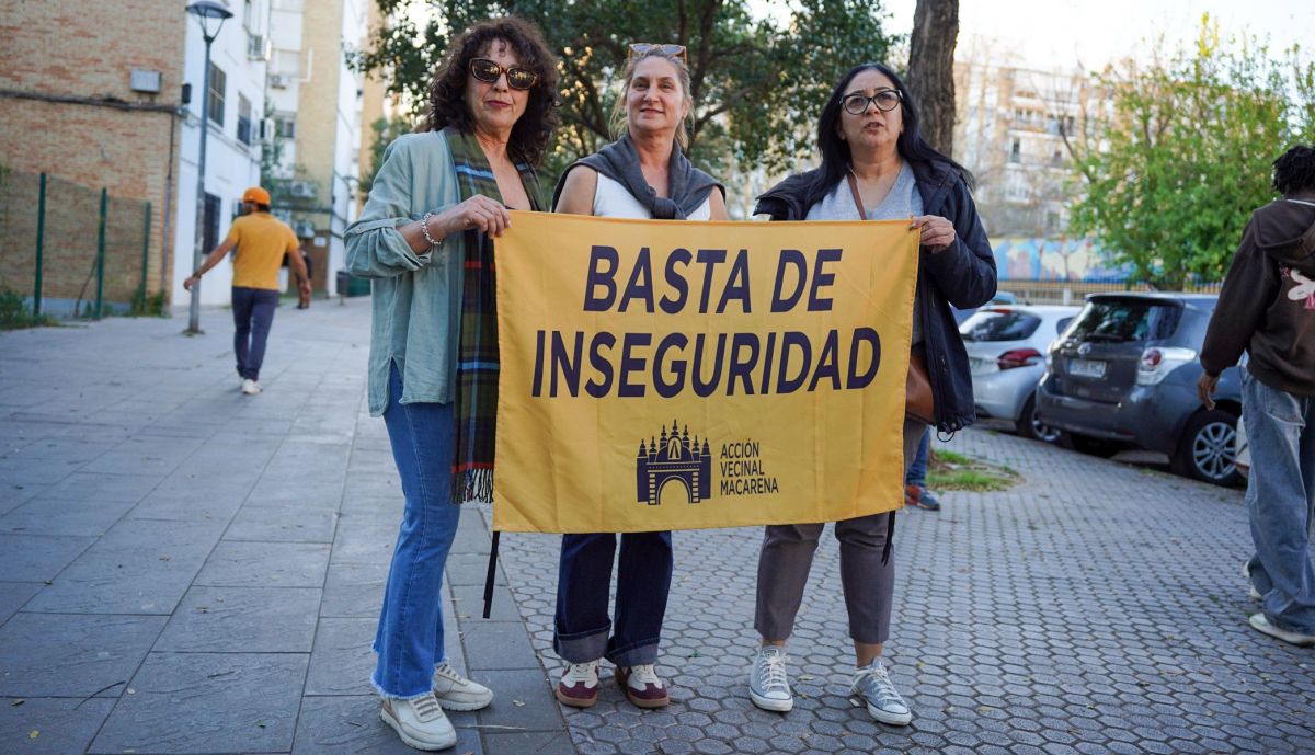 Heidy Duin, a la derecha, sostiene una pancarta reivindicativa junto a otras vecinas tras sufrir la inseguridad junto a su local comercial durante años.