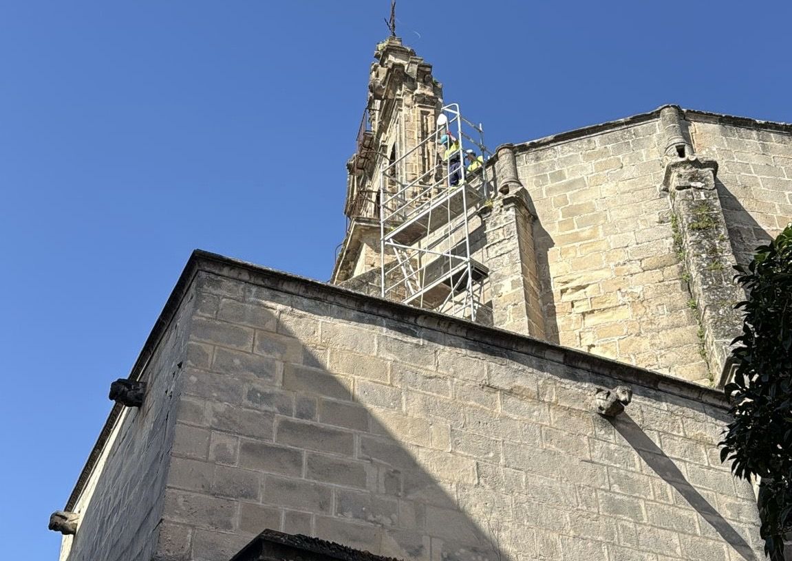 La espadaña con el andamiaje y operarios trabajando esta mañana. 