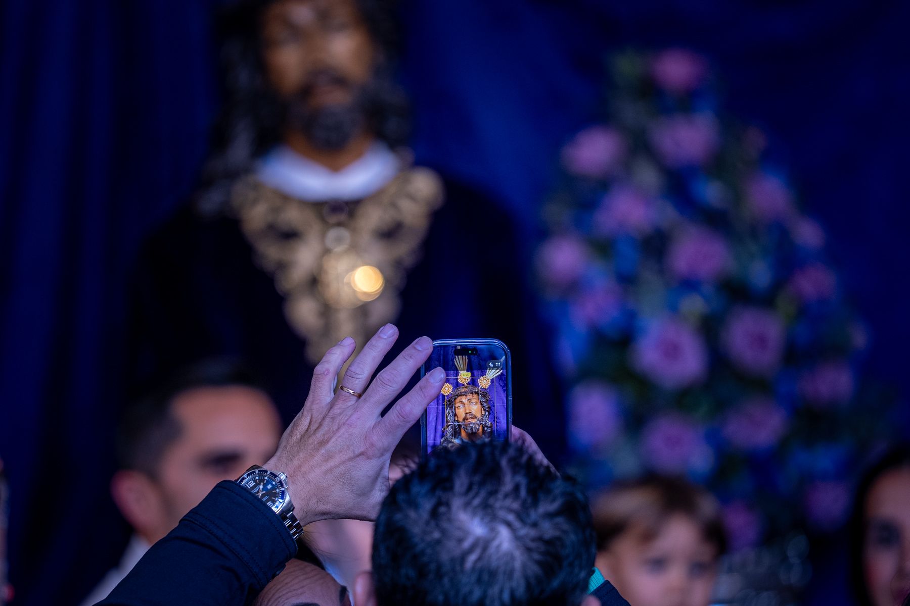 Un devoto tomando una foto a la Sentencia desde la puerta de la Yedra.