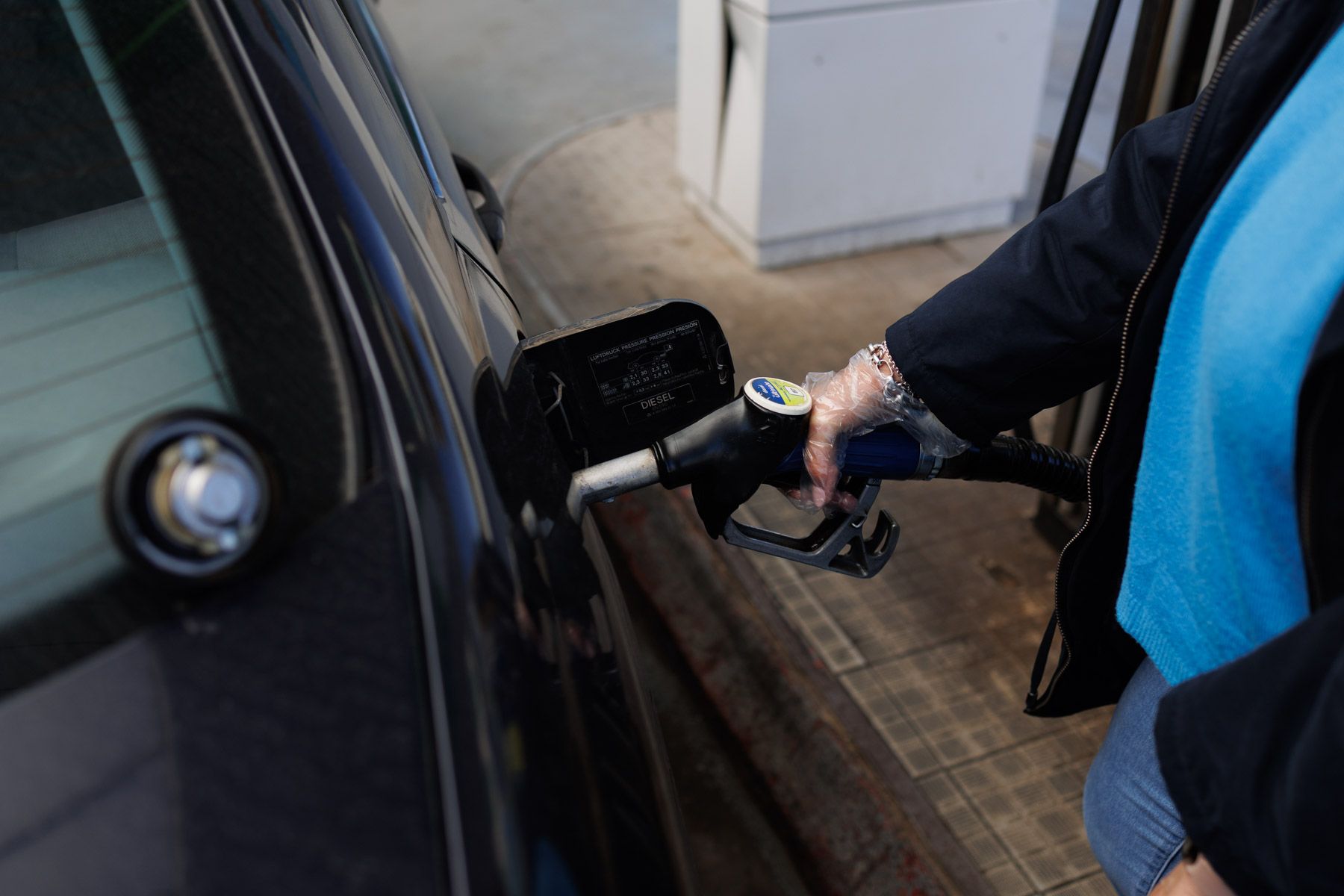 Un conductor repostando en una gasolinera. Un conductor repostando en una gasolinera.