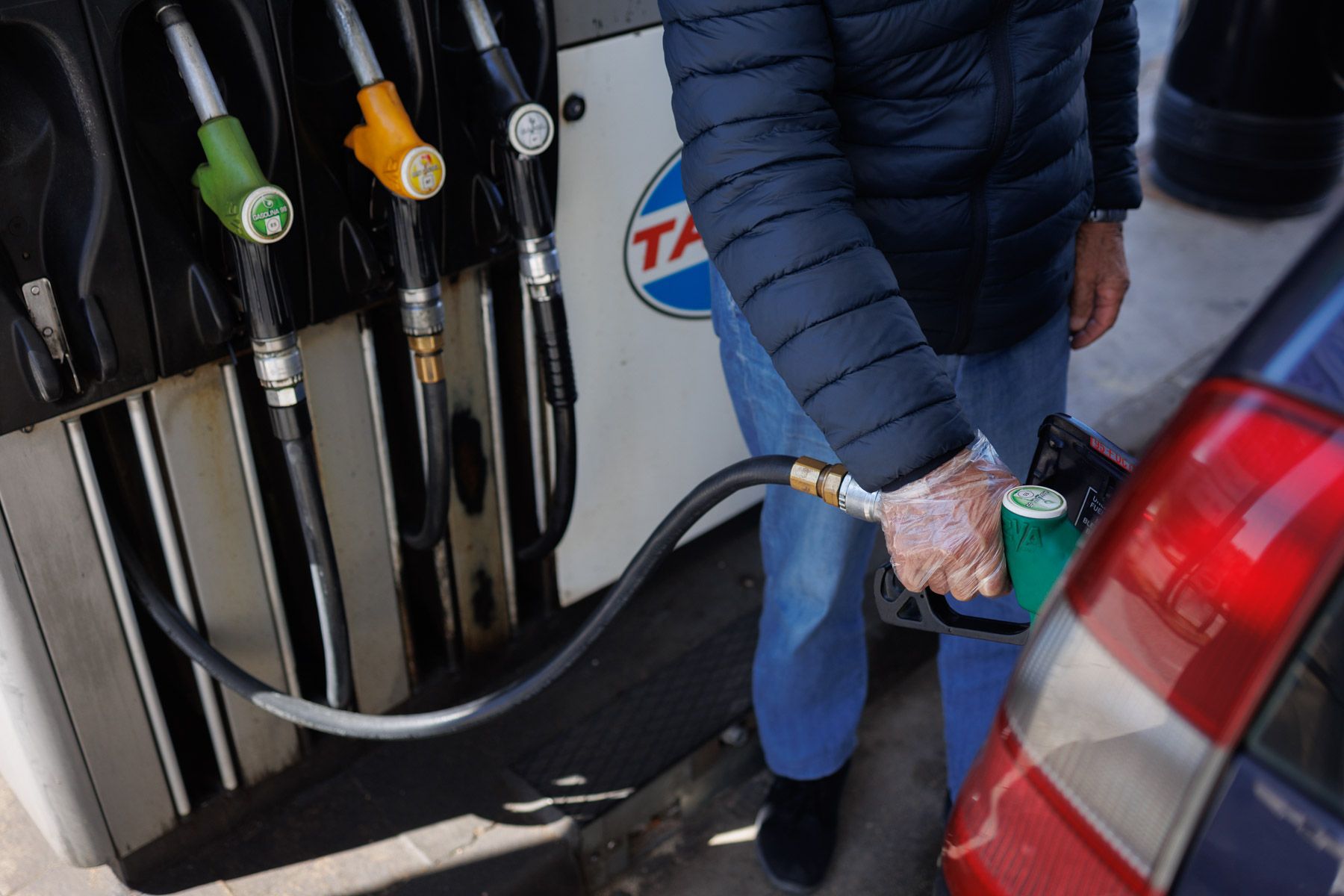 Un hombre repostando gasolina durante la escalada bélica.
