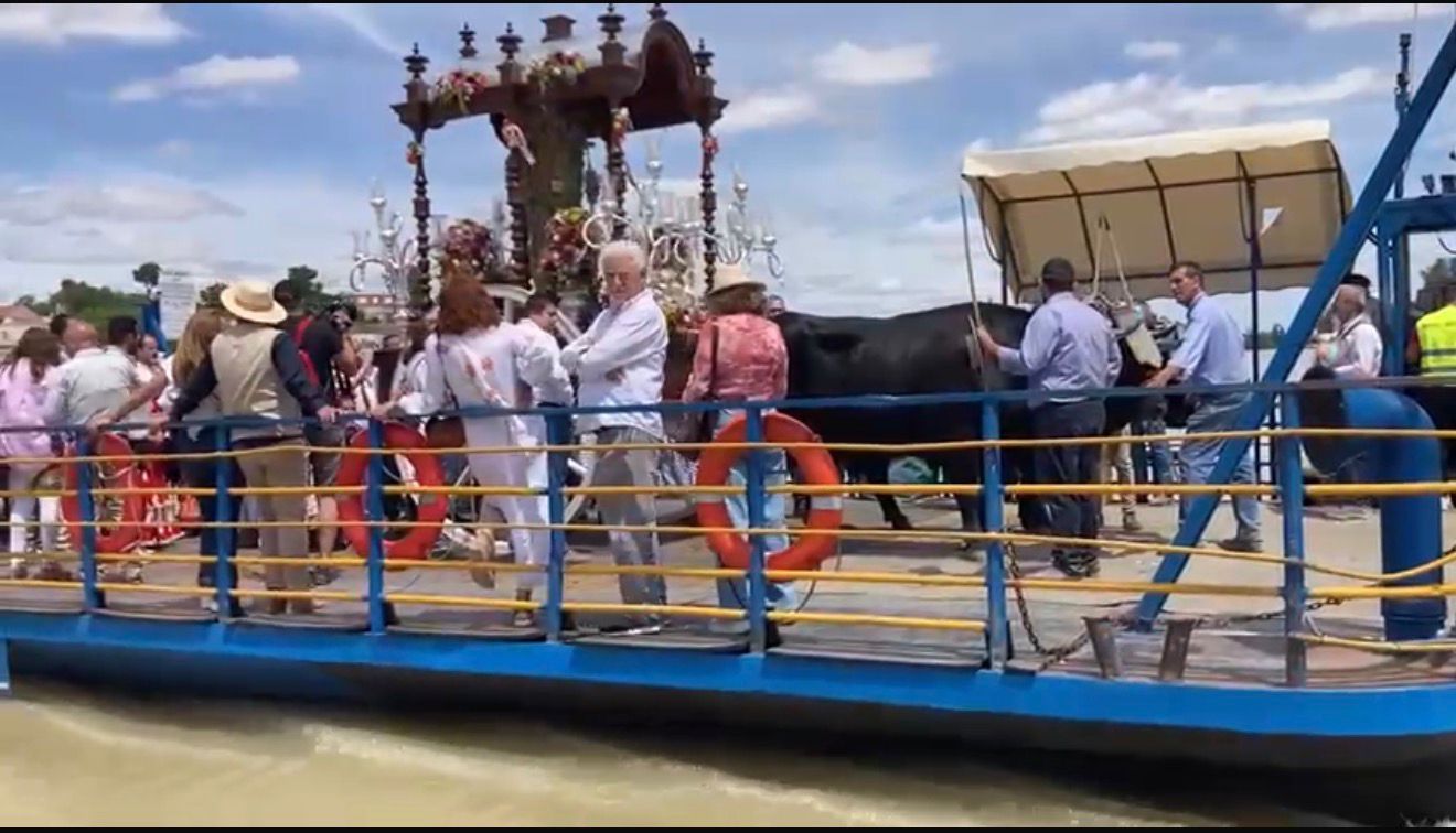 El simpecado de una hermandad cruzando el río en la barcaza de Coria.
