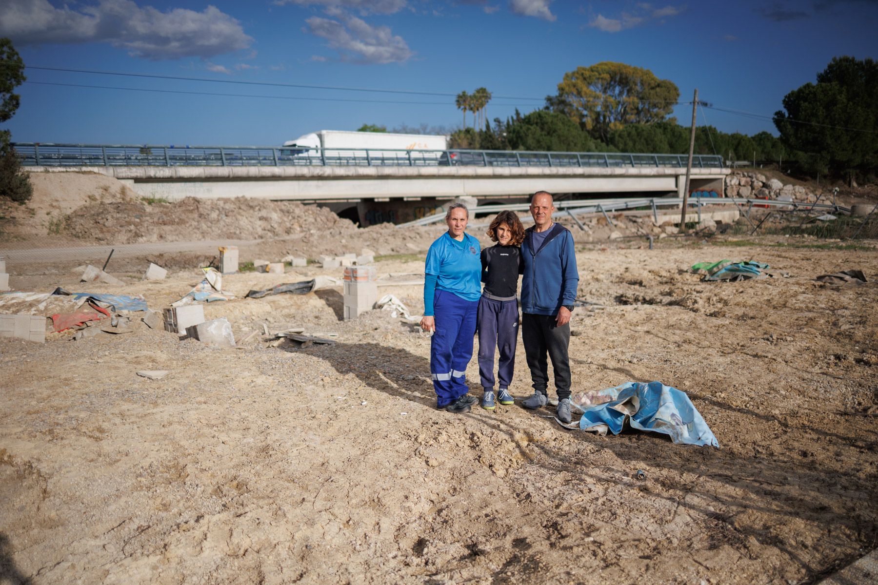 Valeria Blengio, Martín Salceda y su hijo pequeño, en el lugar donde estaba su casa antes de las inundaciones en Las Pachecas.