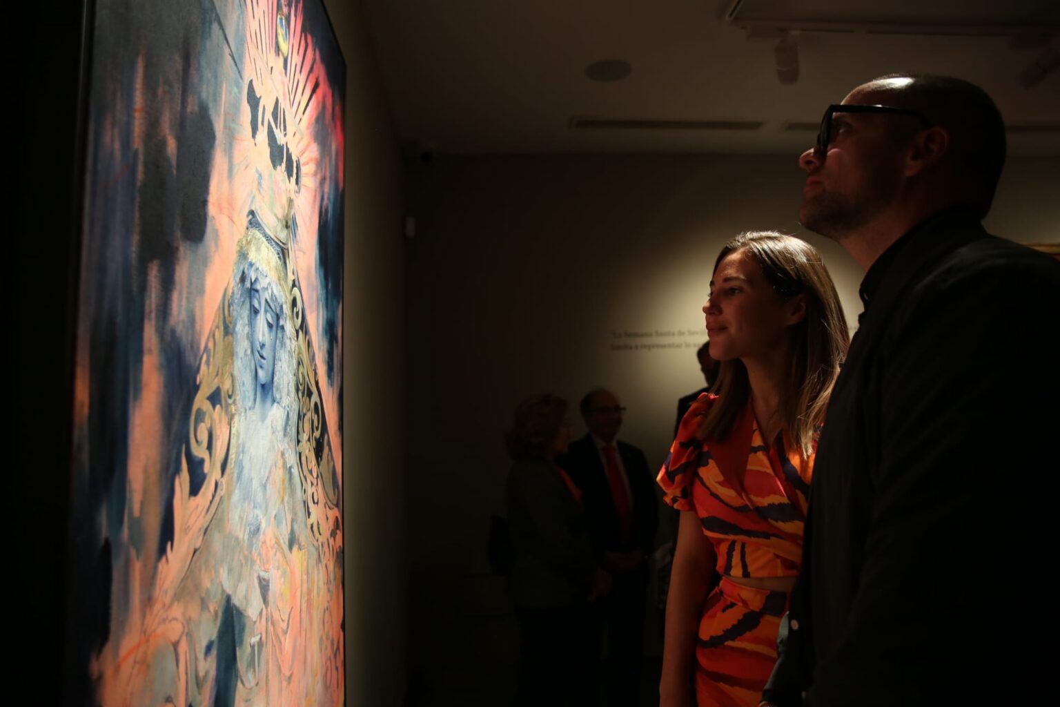 Visitantes a la exposición contemplando una de las obras. 