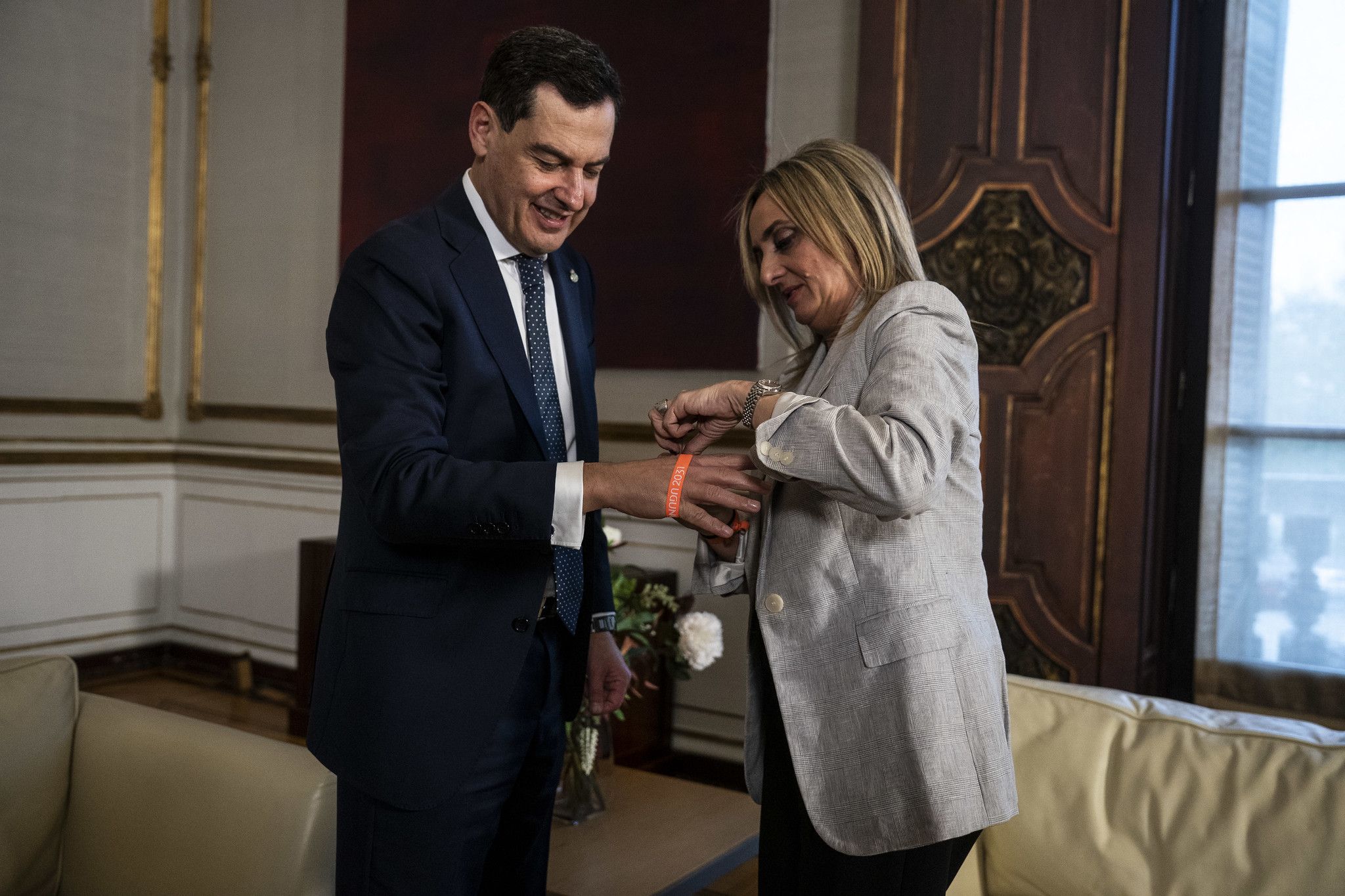 El presidente de la Junta, Juanma Moreno, y la alcaldesa de Granada, Marifrán Carazo, este pasado jueves, mientras la segunda le coloca al primero la pulsera de la candidatura a Capital Europea de la Cultura en 2031.