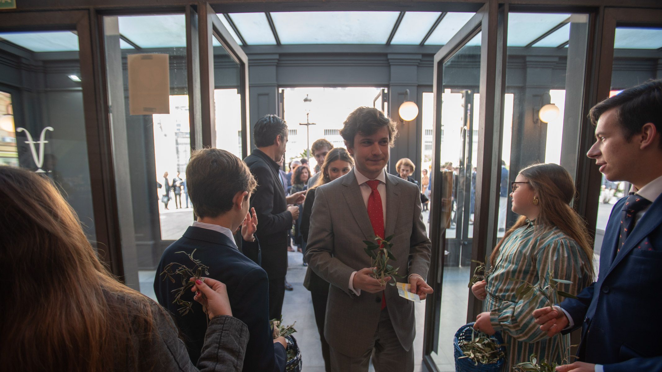 Jóvenes de la Edtrellacentregdndo ramilletes de olivo en la entrada del Villamarta. 