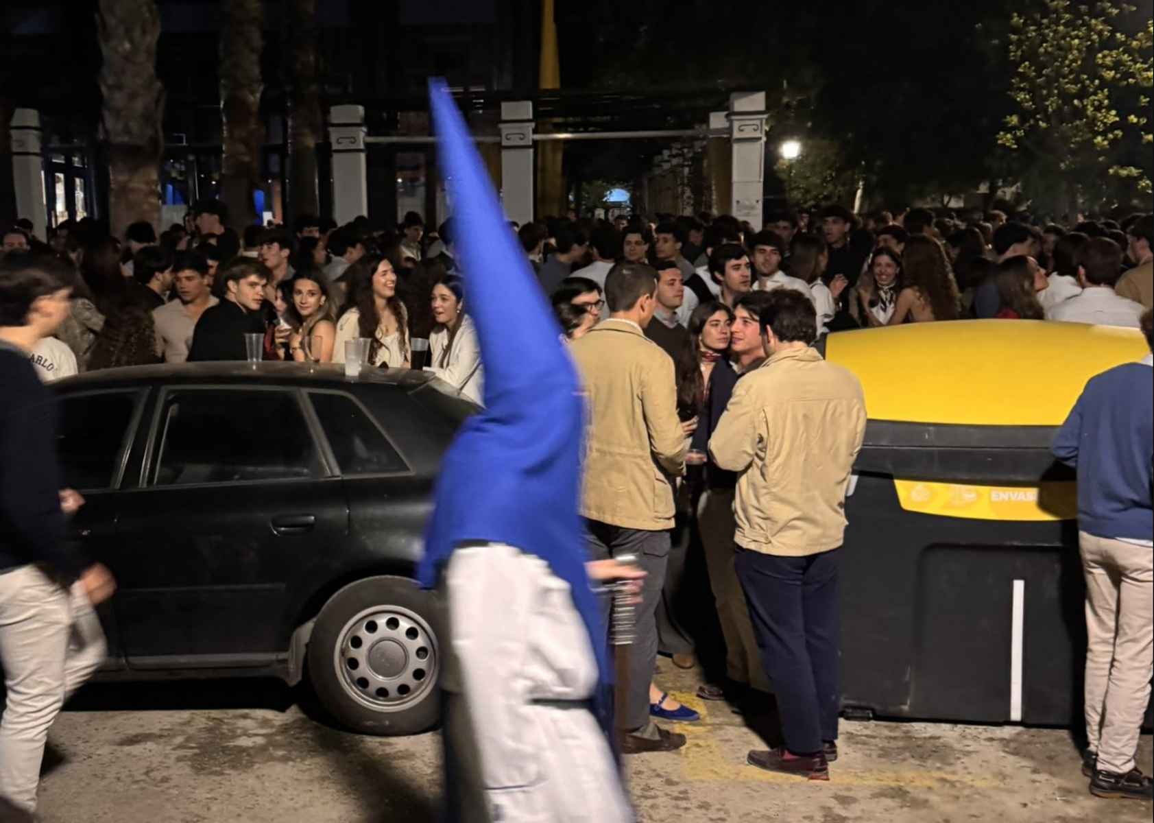 Un nazareno de La Misión, con jóvenes al fondo. Un nazareno de La Misión, con jóvenes al fondo.