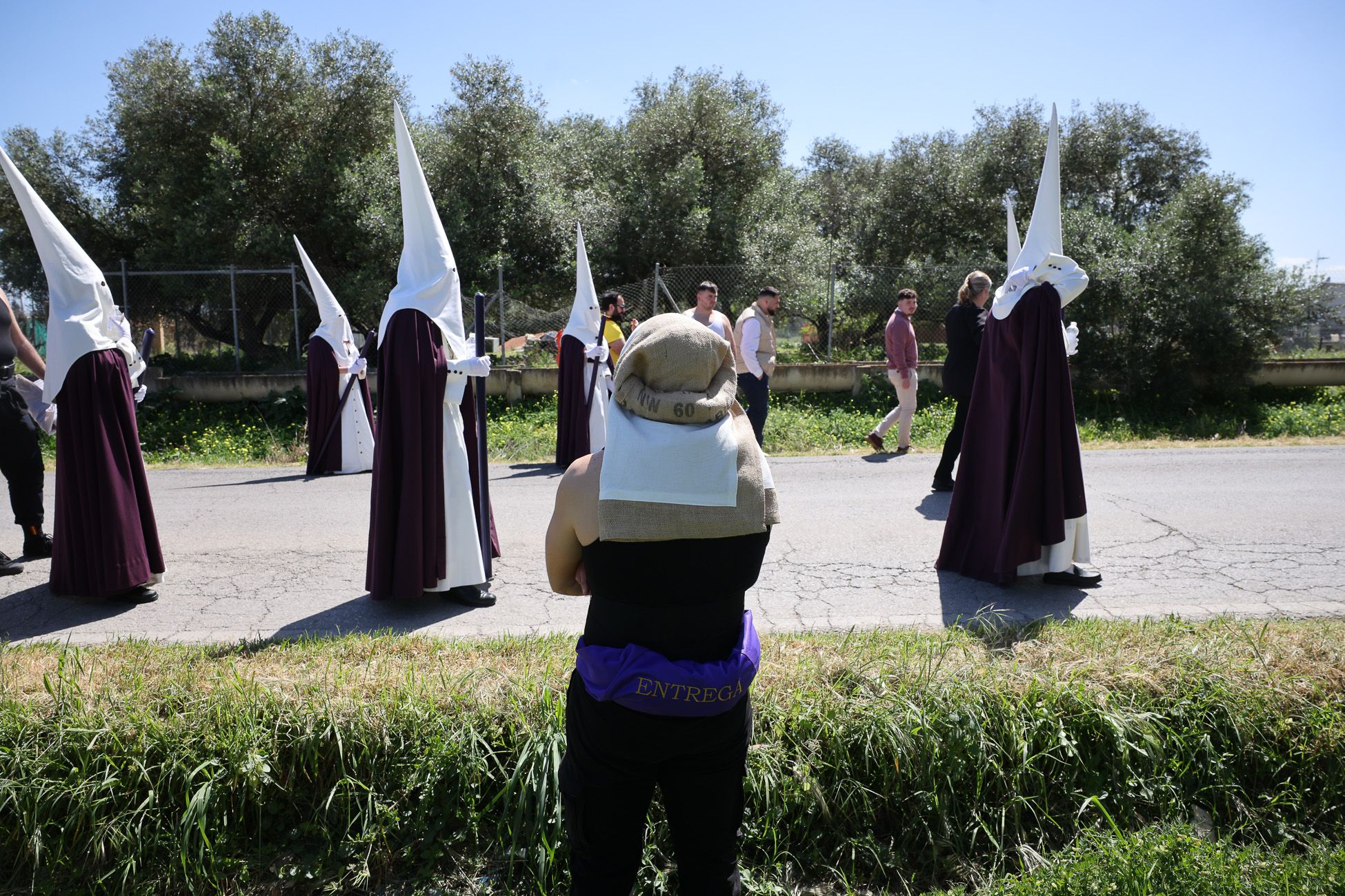 Otro momento del caminar de la Hermandad de La Entrega por la carretera de San José Obrero.