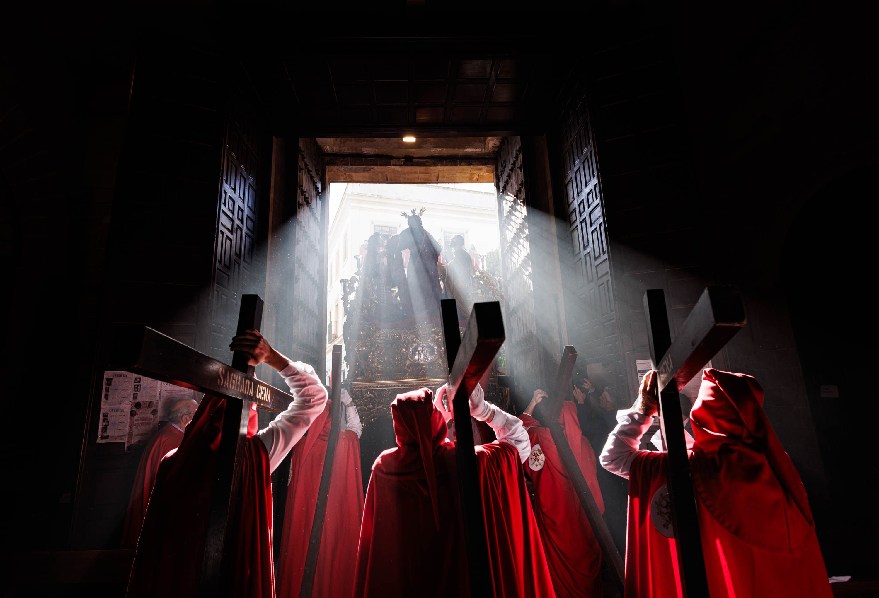 Momento en el que el misterio de La Cena traspasa el dintel y los rayos de luz de la puerta principal de San Marcos, este Lunes Santo en Jerez.