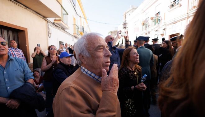 Antonio El Chusco, primo de La Paquera, observando el discurrir de la cofradía a la altura de la casa natal de la artista.