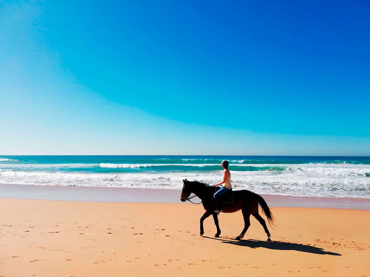 Una mujer pasea a caballo por las playas de Conil, en una imagen de archivo.