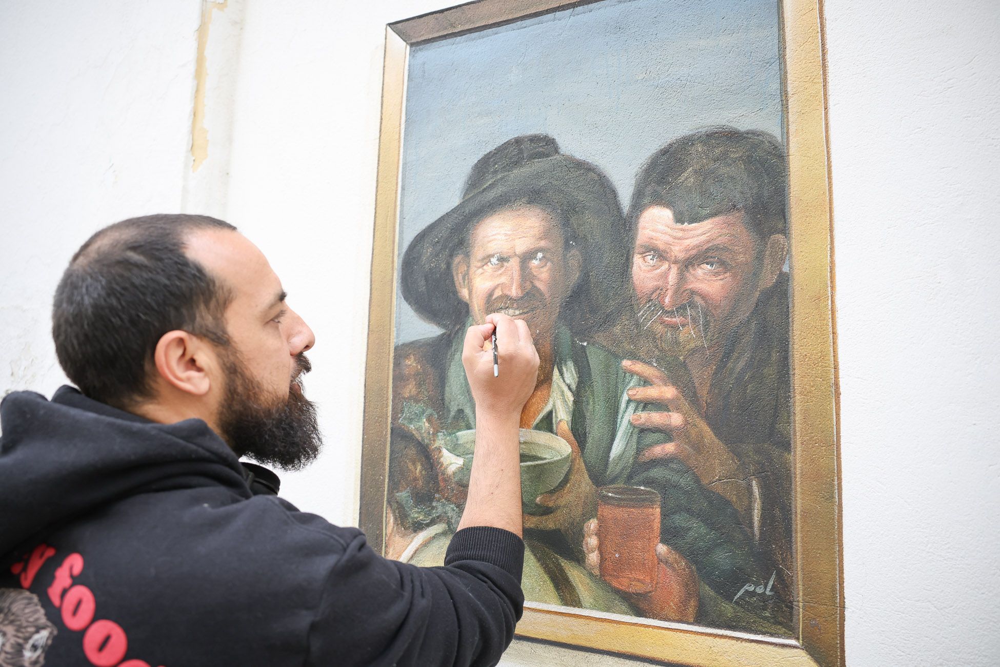 Pol Tatoo arregla el destrozo en su obra de 'Los Borrachos', en el entorno de la plaza del Progreso.