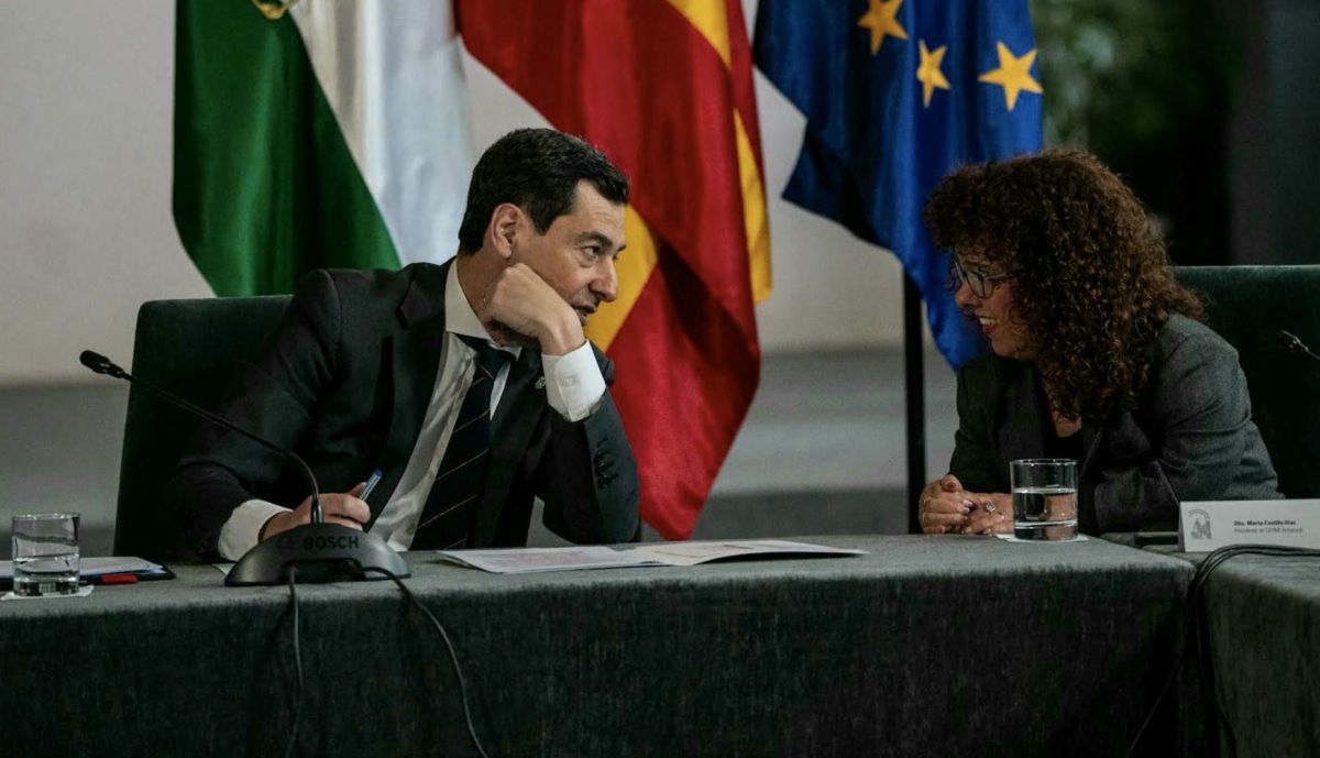 Juanma Moreno conversa, en un momento del encuentro, con la presidenta de Cermi Andalucía, Marta Castillo.