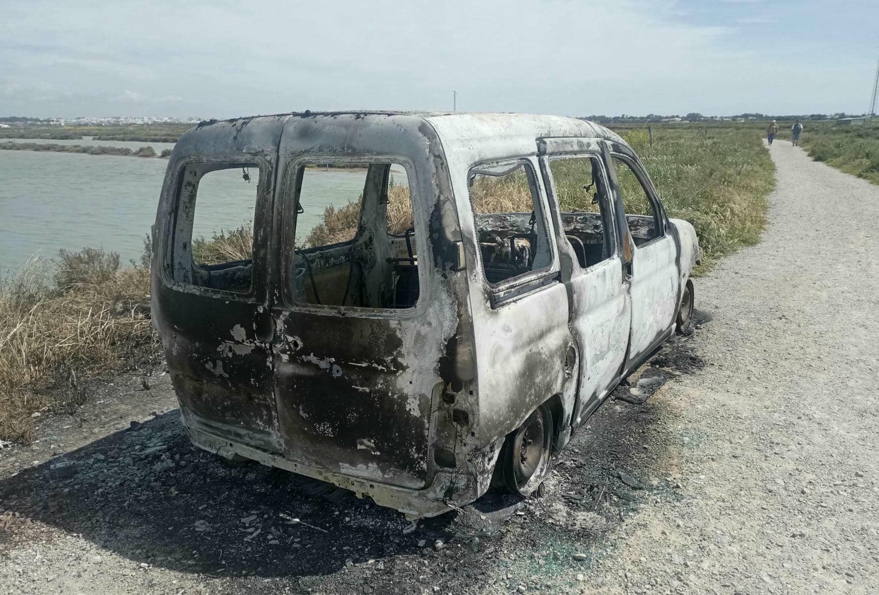Una furgoneta calcinada en la ruta de los Esteros en Chiclana.