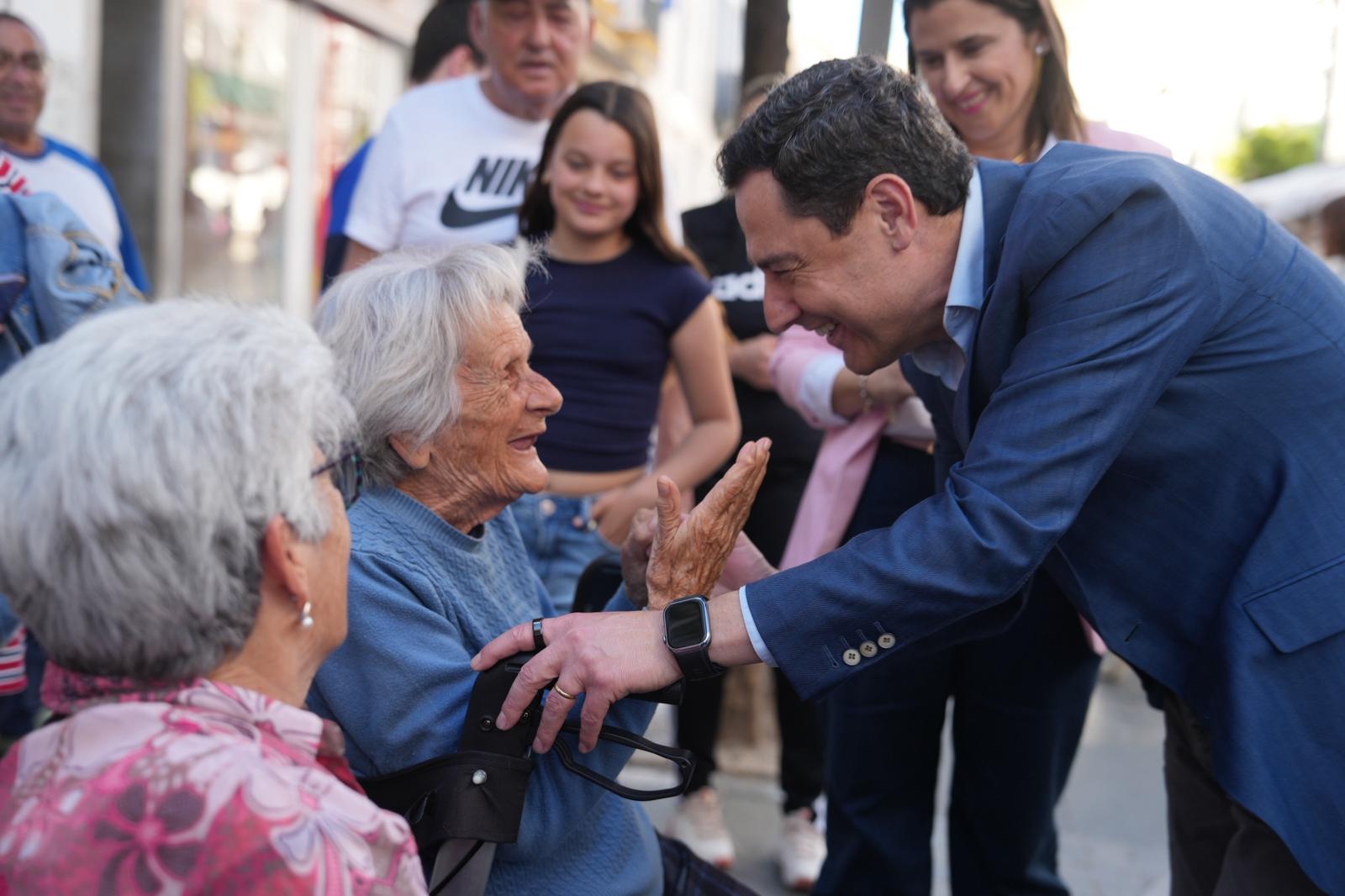Juanma Moreno saluda a unas señoras mayores este viernes en Sanlúcar.