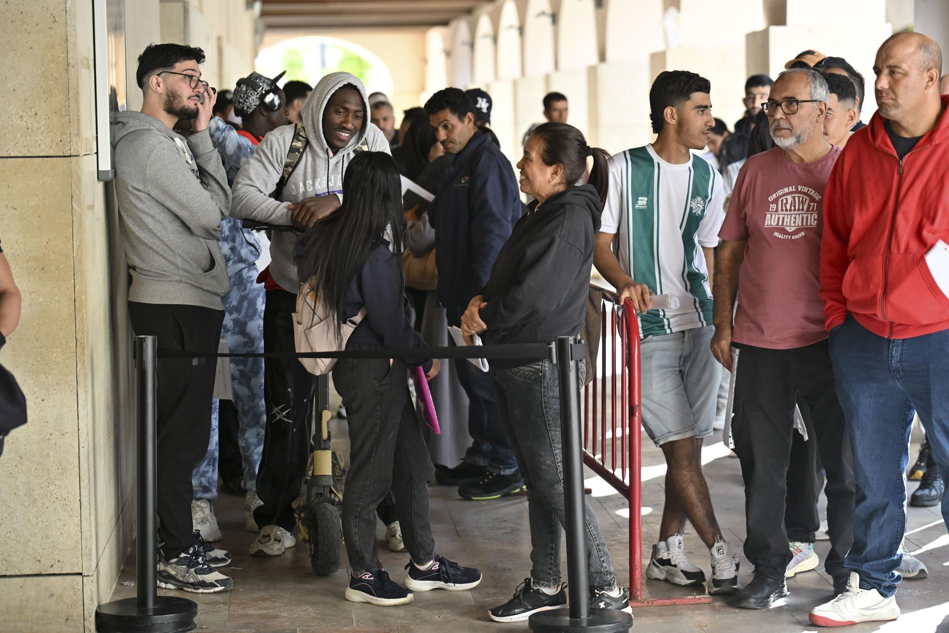 Largas colas para regularizar la situación de migrantes.