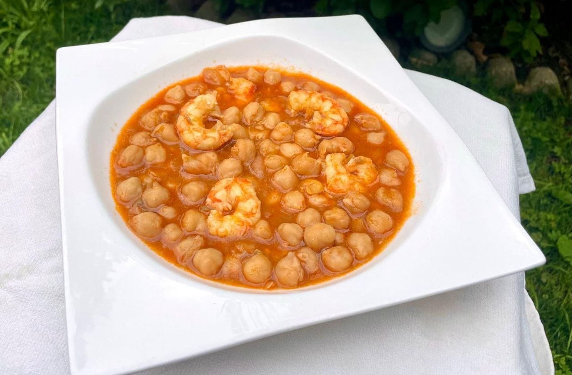 Un plato de garbanzos con langostinos.