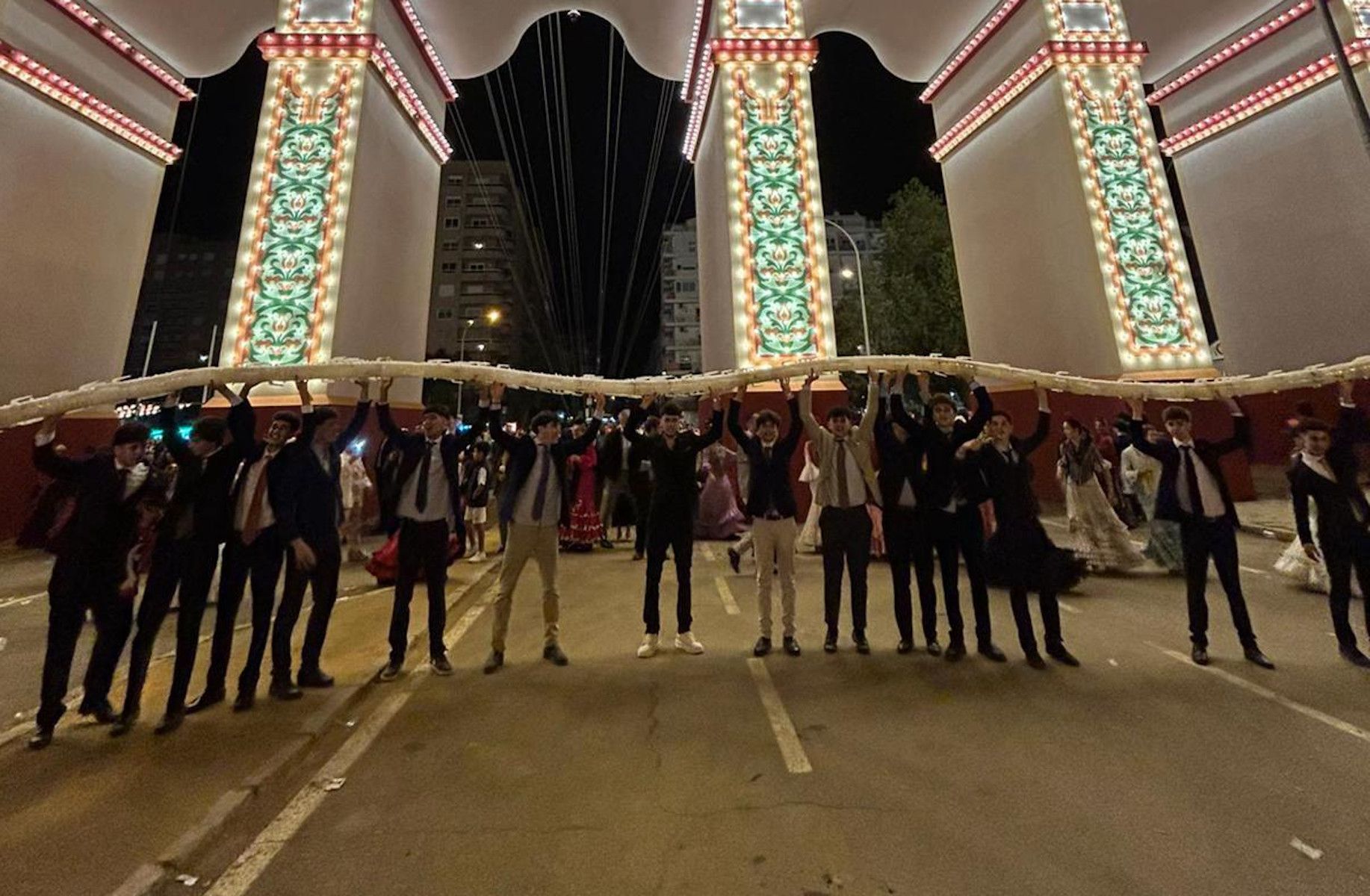 Los jóvenes, con la 'serpiente' de jarras de rebujito en la portada de la Feria de Sevilla.