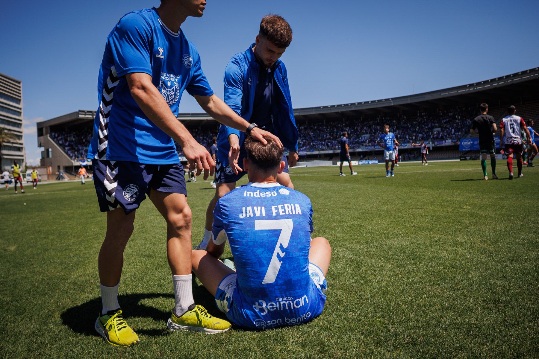 Javi Feria, tras el pitido final, siendo consolado.