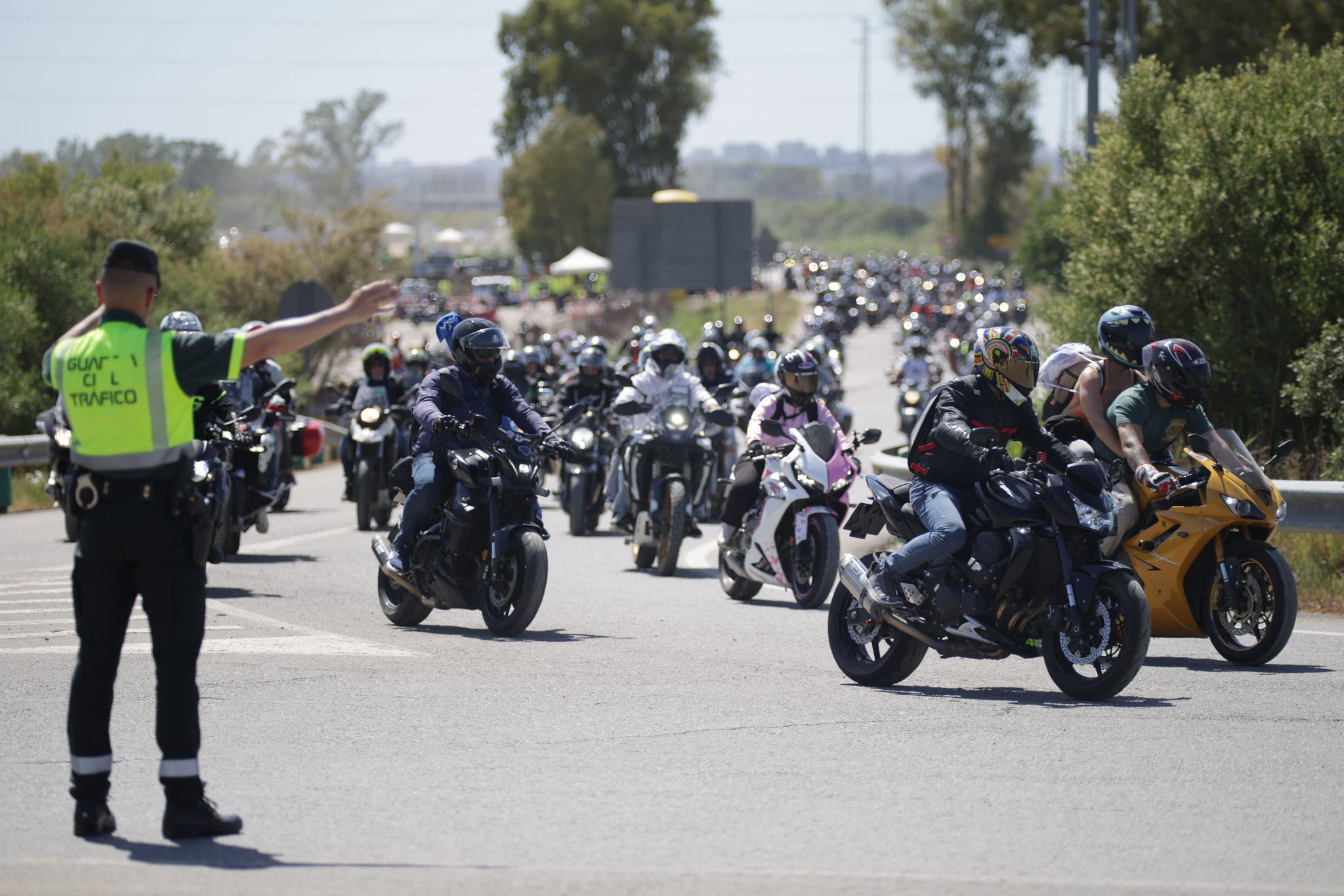 Un guardia civil dirige a las motos tras salir del circuito.