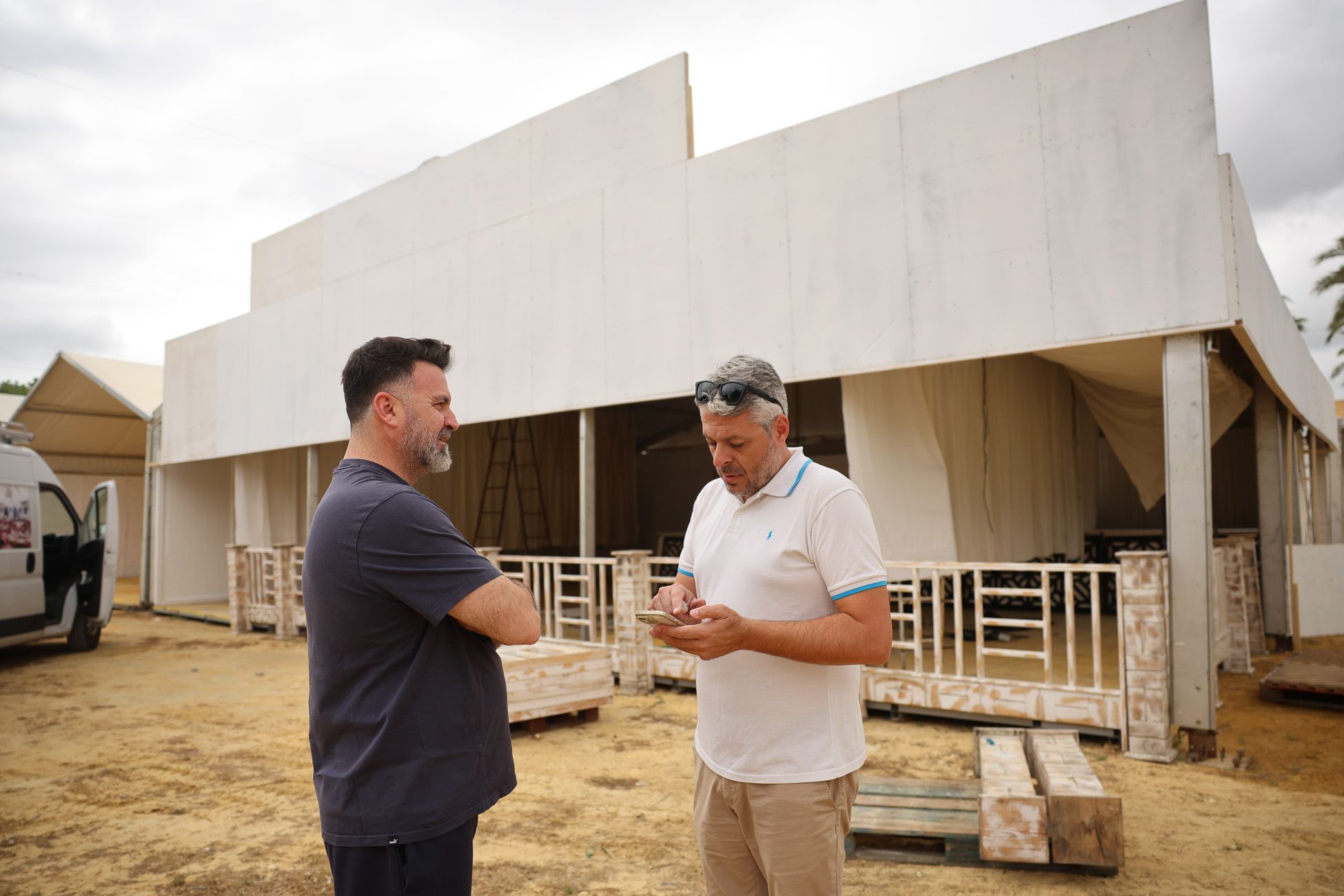 Lo hermanos mayores de Pasión y Exaltación en el Real ocupados en el montaje de sus respectivas casetas.
