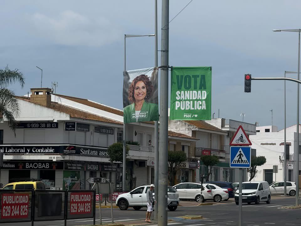 El cartel del PSOE Andalucía rompe con el acuerdo establecido en Lepe de evitar coincidir la publicidad electoral con la romería de la Bella.