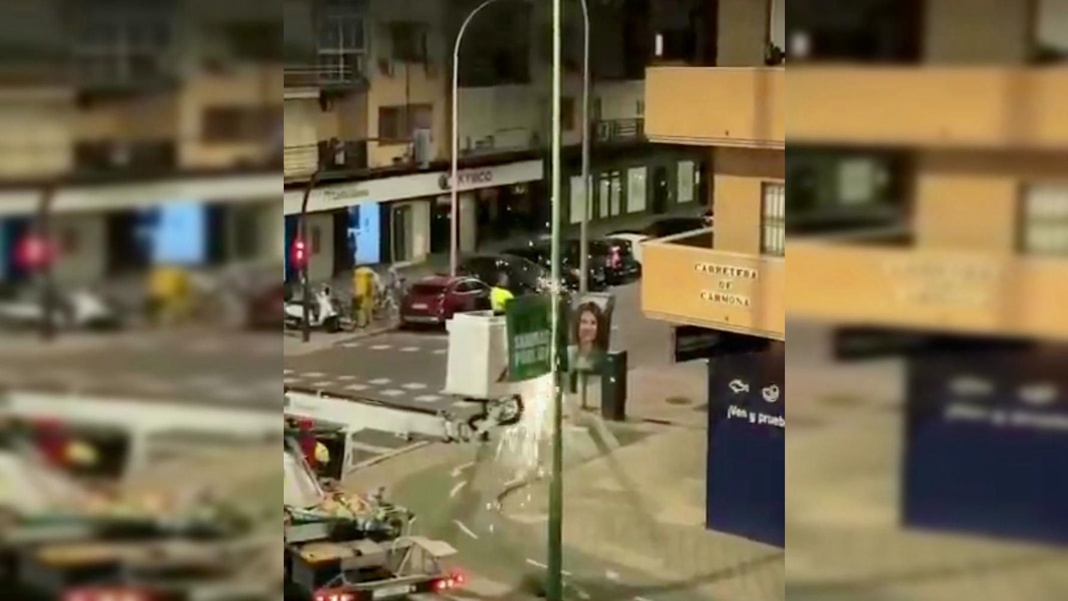 Retirada de carteles del PSOE en Sevilla por parte de operarios municipales.