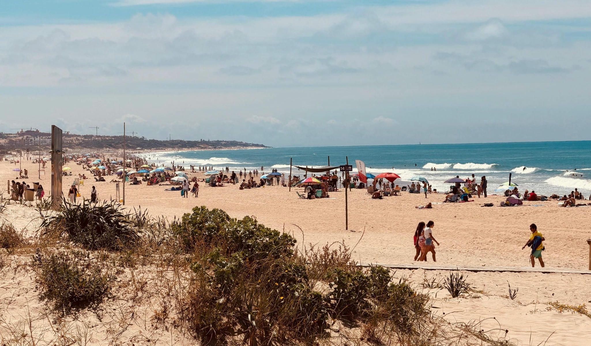 Con un tiempo primaveral, algunos visitantes aprovechan sus últimas horas de vacaciones en La Barrosa