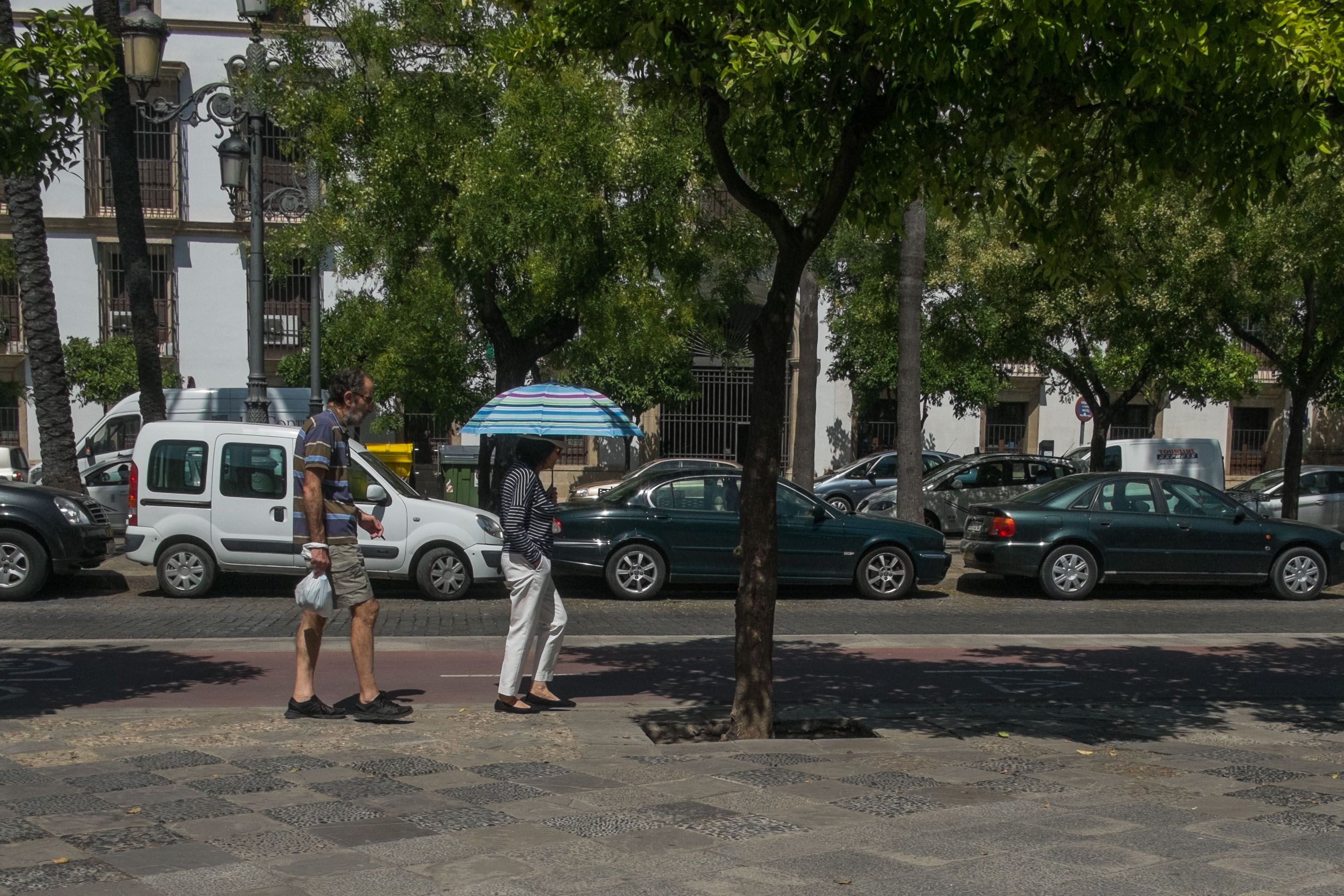 Una mujer protegiéndose del sol con un paraguas. FOTO: MANU GARCÍA. 