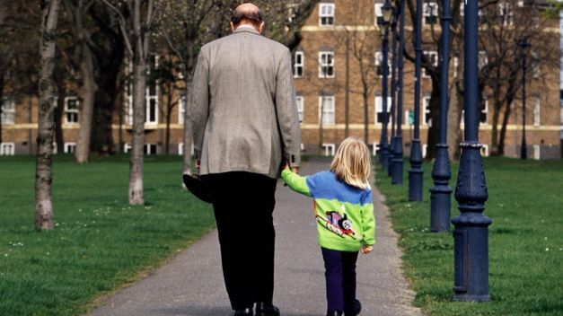 Un abuelo paseando con su nieta.