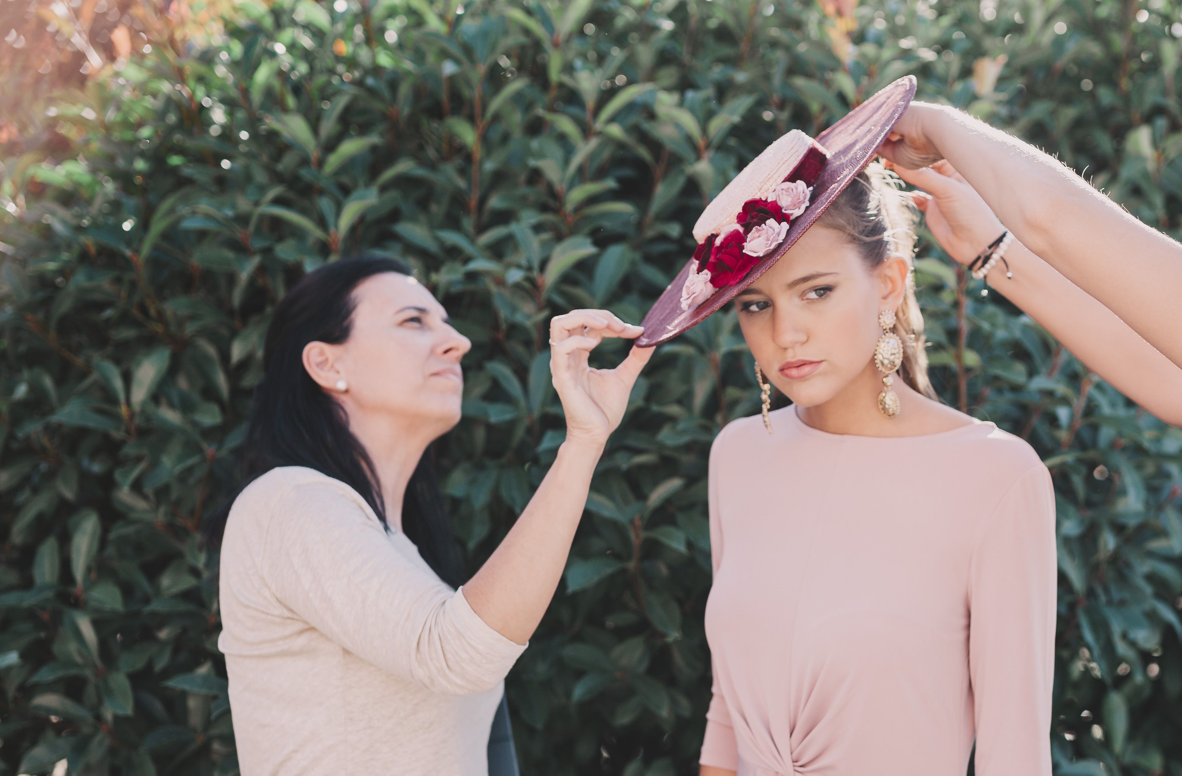 Carmen González (izq.) colocando uno de sus sombreros a la modelo. FOTO: ÓSCAR LÓPEZ.