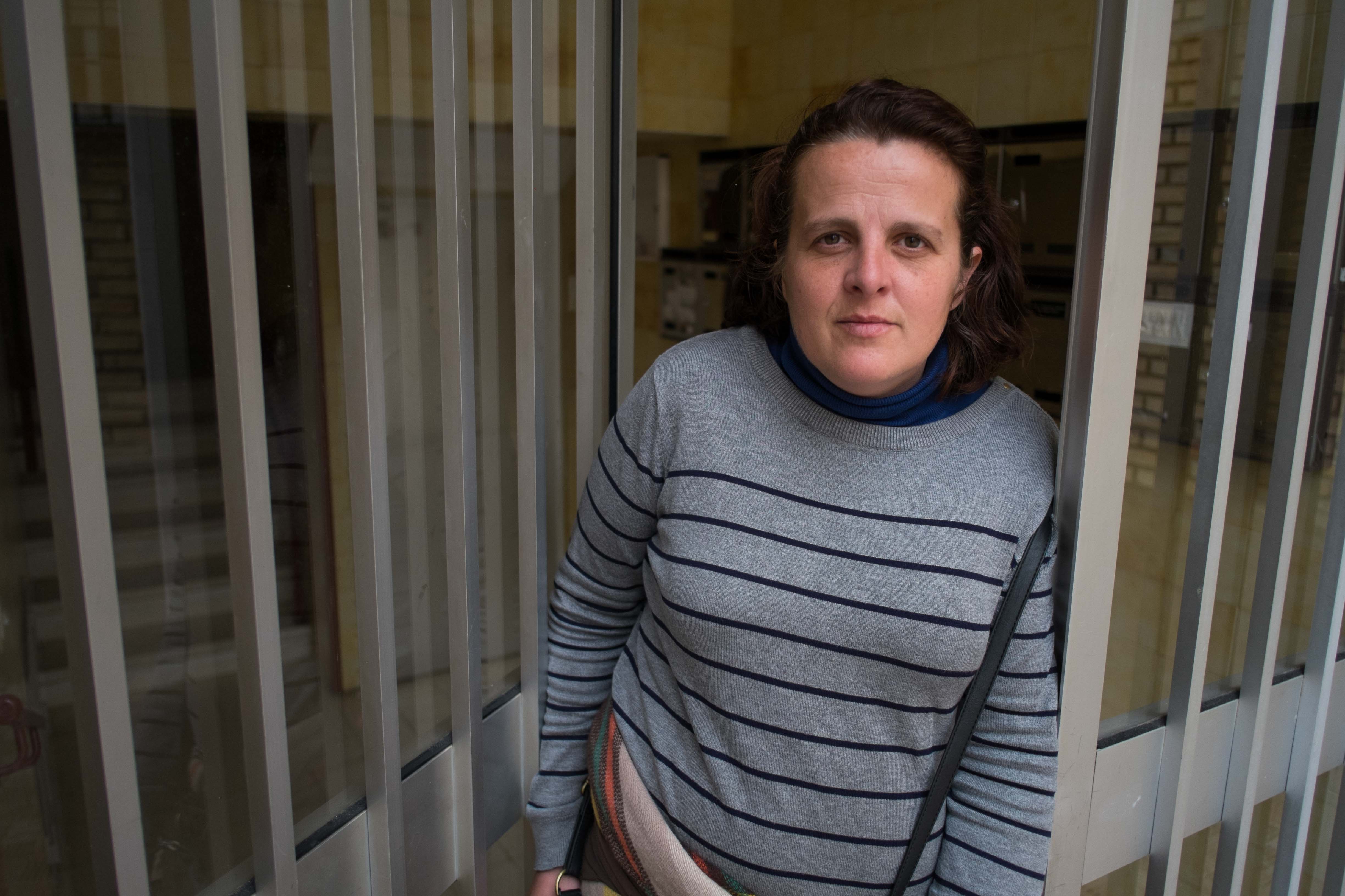 María del Amor, en la puerta del bloque donde vive con sus dos hijos. / MANU GARCÍA.