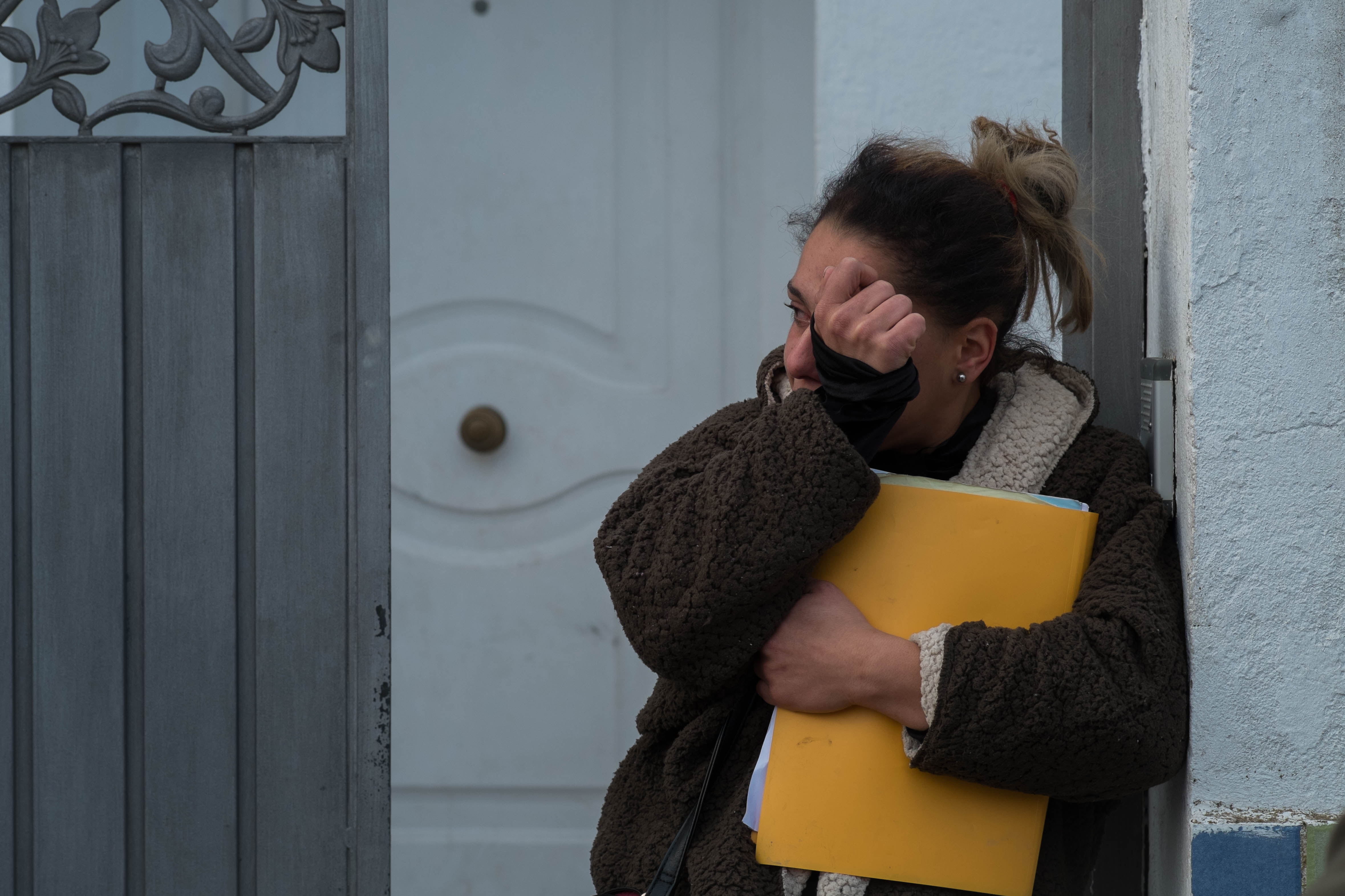 Sandra, secándose las lágrimas, a las puertas de la vivienda que okupaba. / MANU GARCÍA.