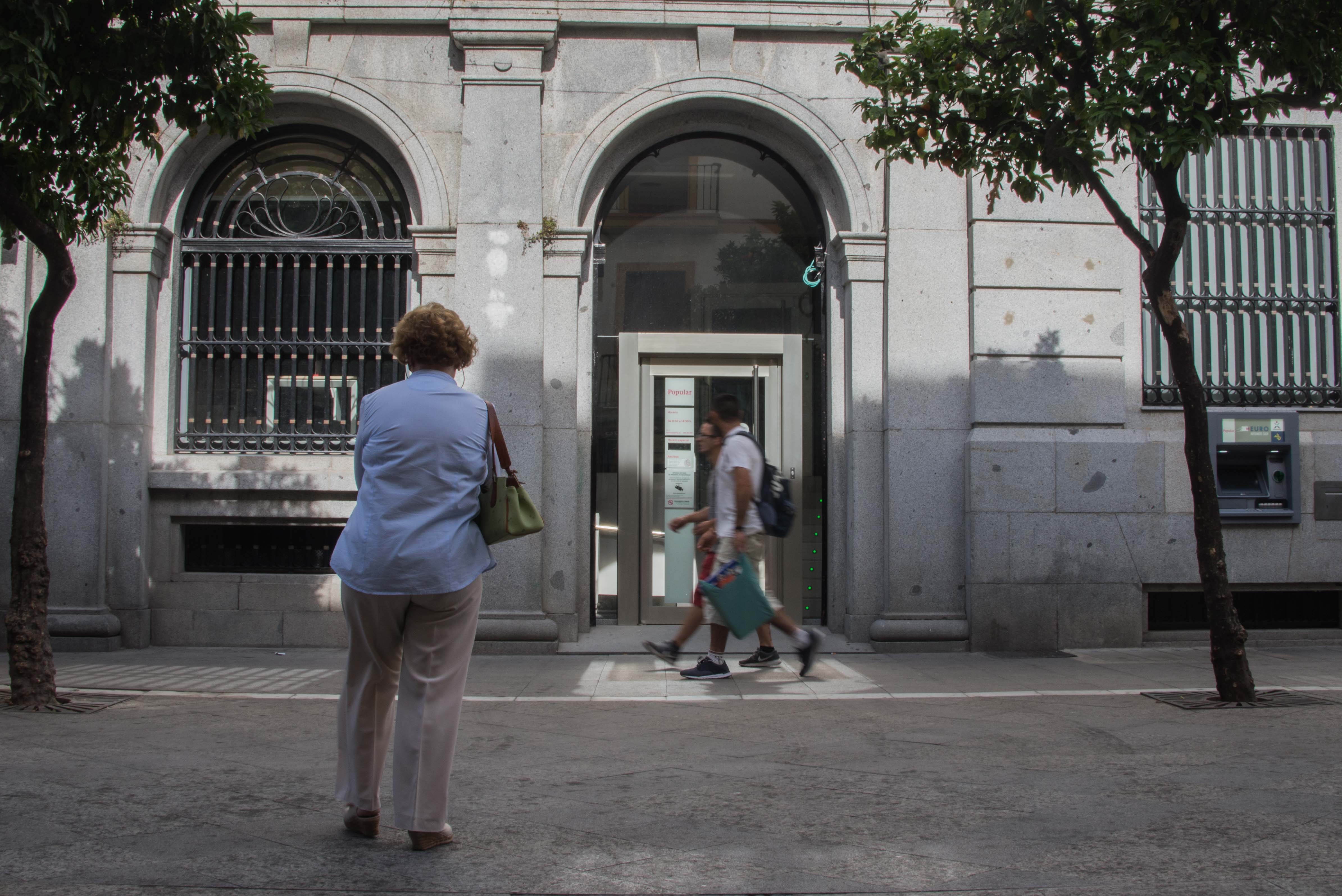 Una clienta espera en la puerta de una sucursal de banca, en Jerez, en una imagen de archivo.