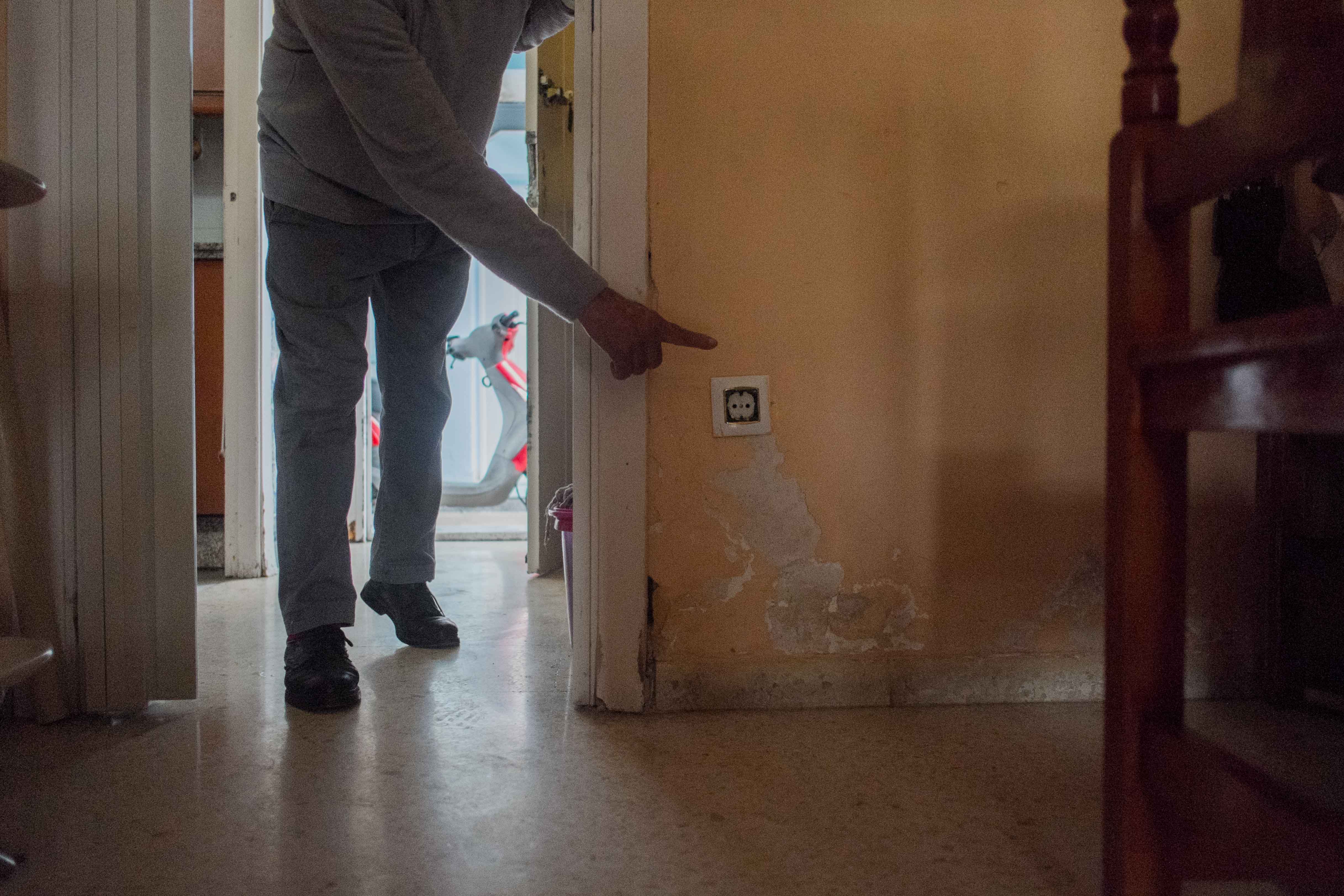 Un vecino, señalando las manchas de humedad en una de las viviendas de 'Los Pitufos', en una imagen de archivo. FOTO: MANU GARCÍA