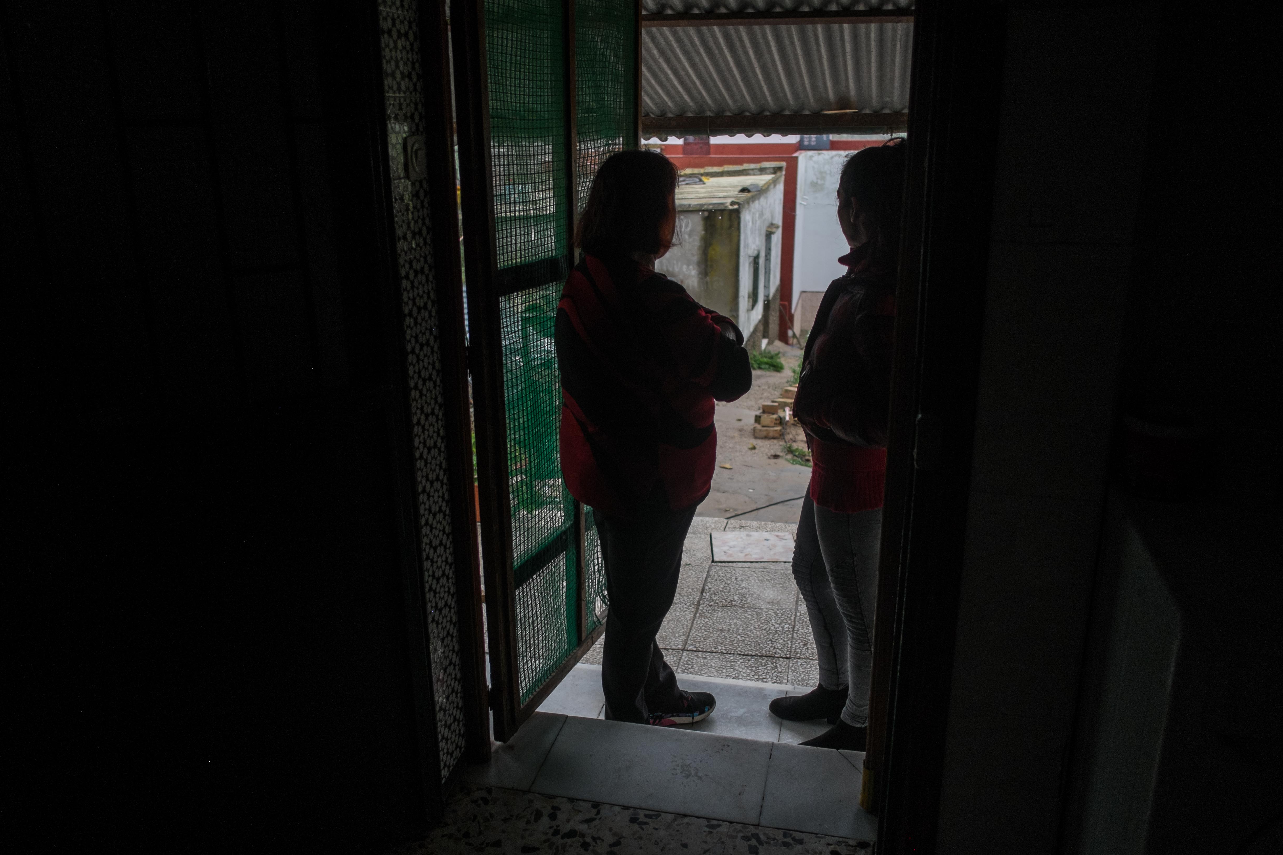 Carmen y Natalia, madre e hija, en la puerta de la vivienda ruinosa donde reside la primera. / MANU GARCÍA.