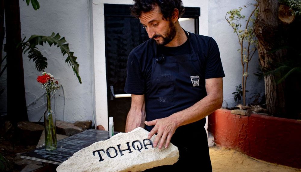 Edu Pérez sujetando la 'tohqa' colocada a la entrada del restaurante. FOTO: JUAN CARLOS TORO