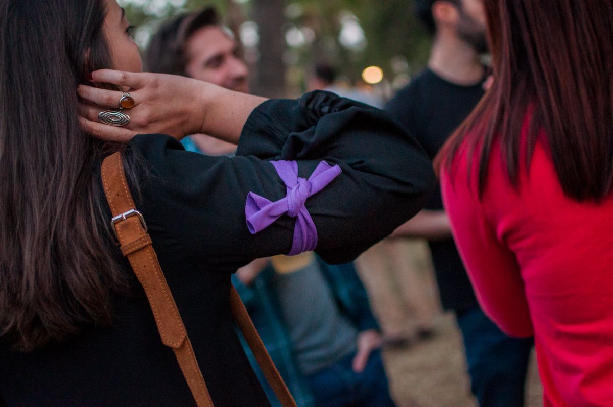 Detalle de una joven con un brazalete morado en el parque junto al Real de la Feria del Caballo. FOTO: MANU GARCÍA.