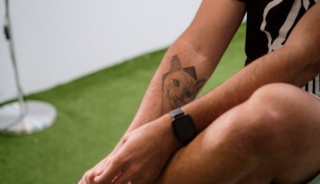 El brazo de Diego Villalba, con un tatuaje de 'mediogramo', el gato de 'Er Christian'.