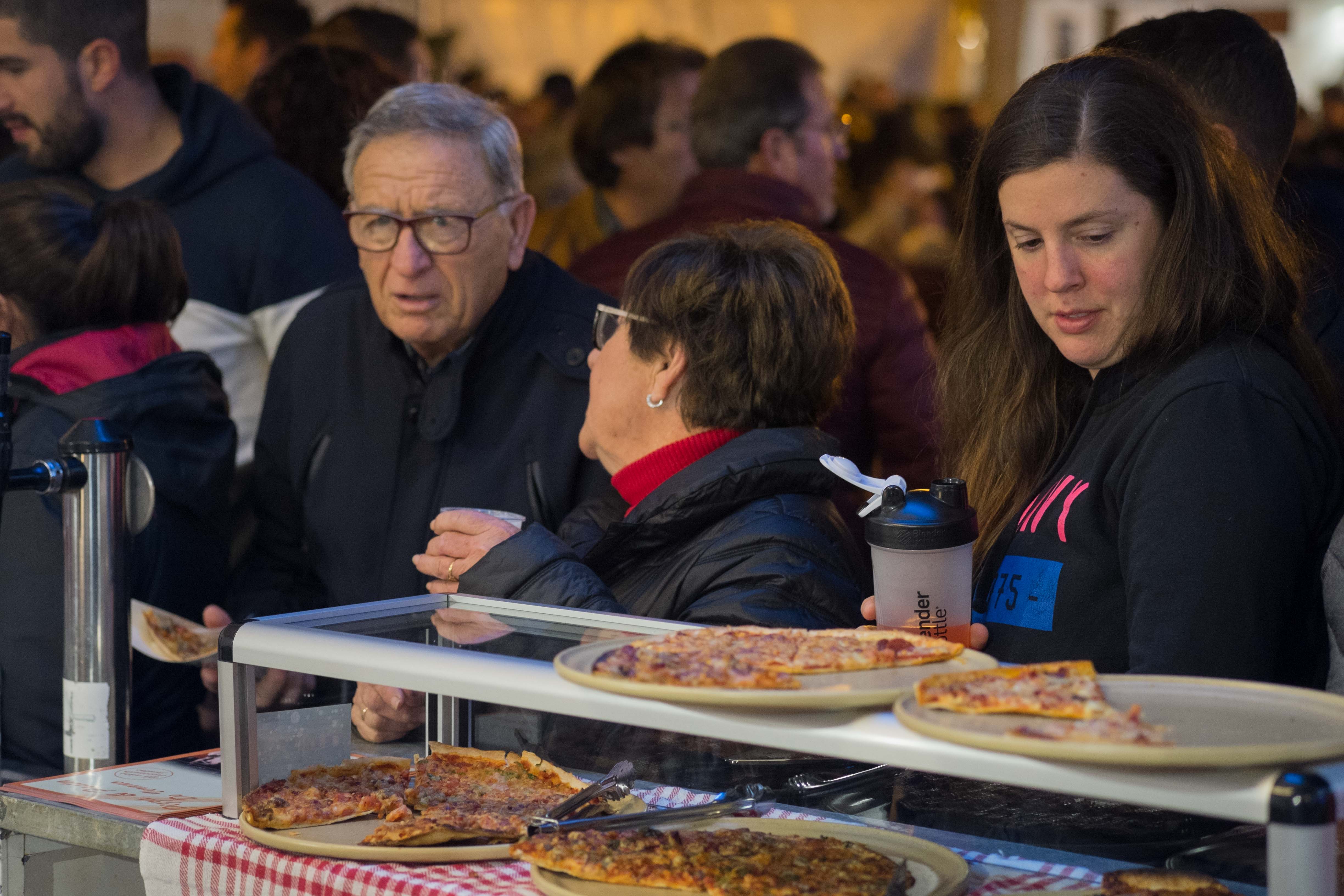 Personas disfrutan de una pizza en un festival gastronómico, en una imagen de archivo. 